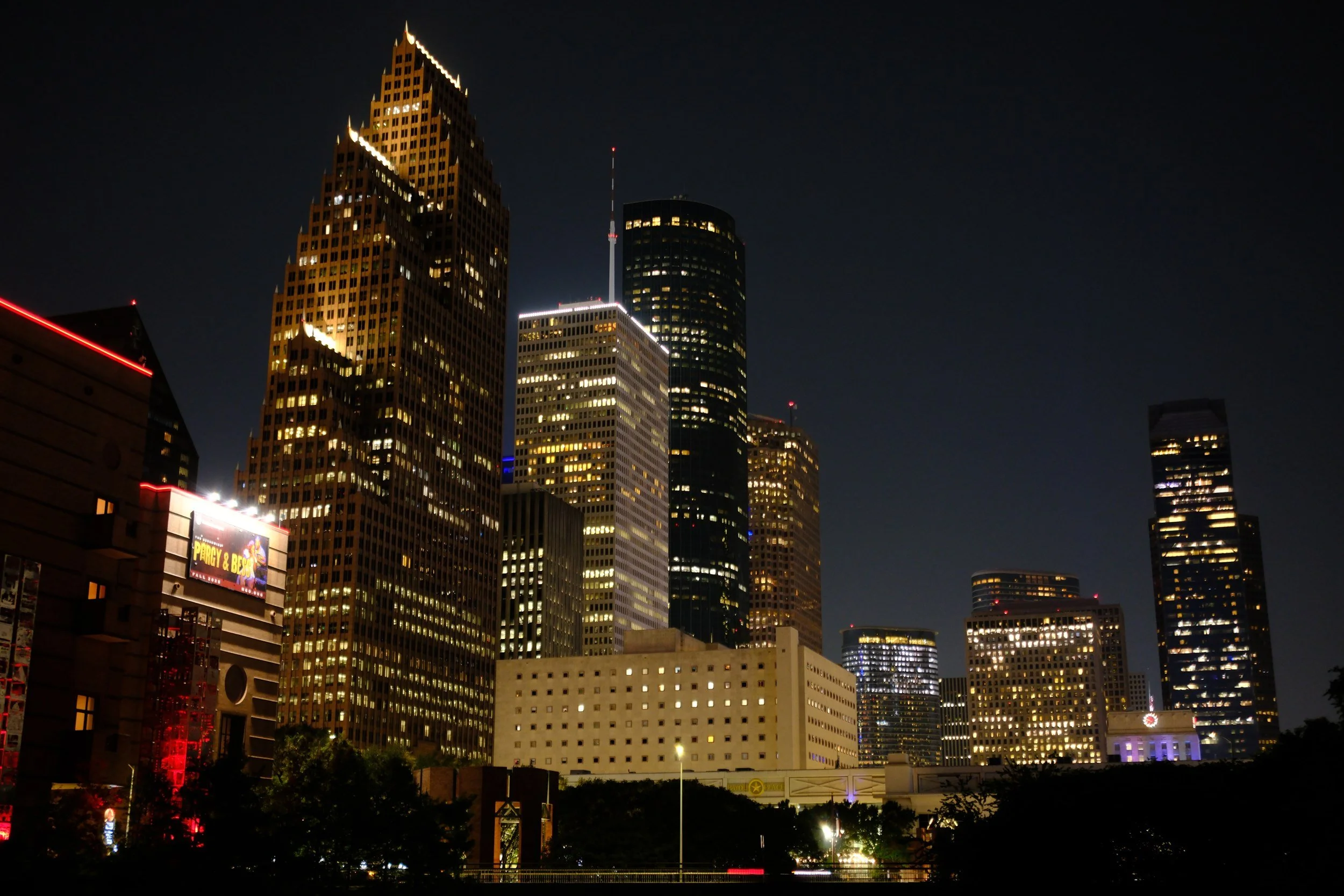 The skyline from the bayou after dark — the golden tower doing all the talking.