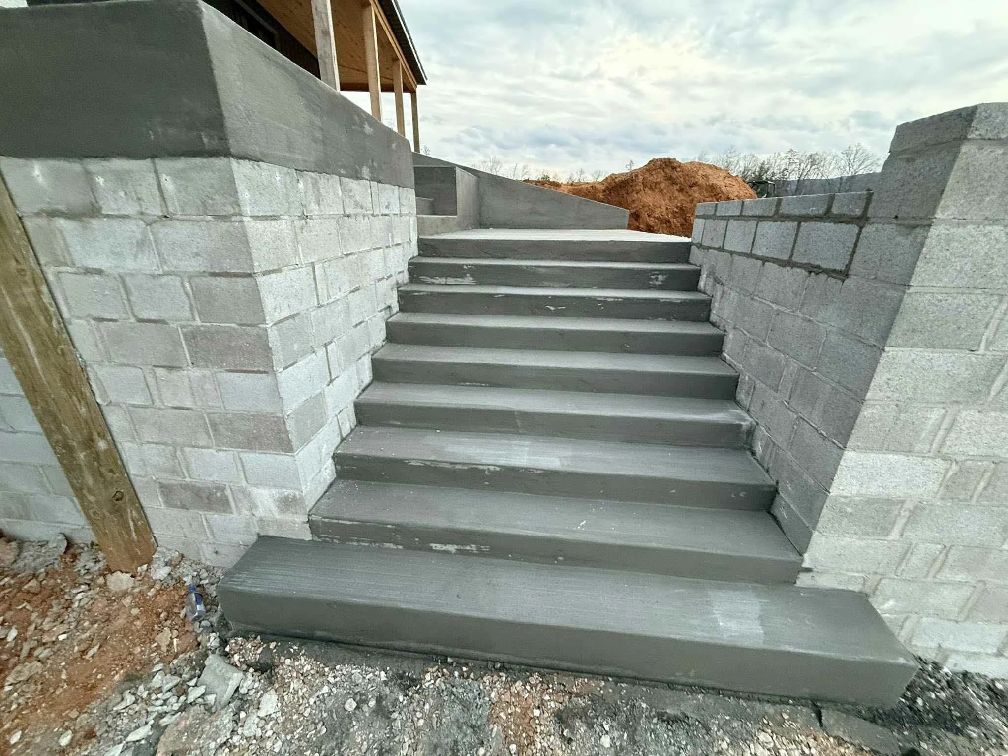 Concrete stairs in Manchester TN with smooth poured steps and block retaining walls at new construction home