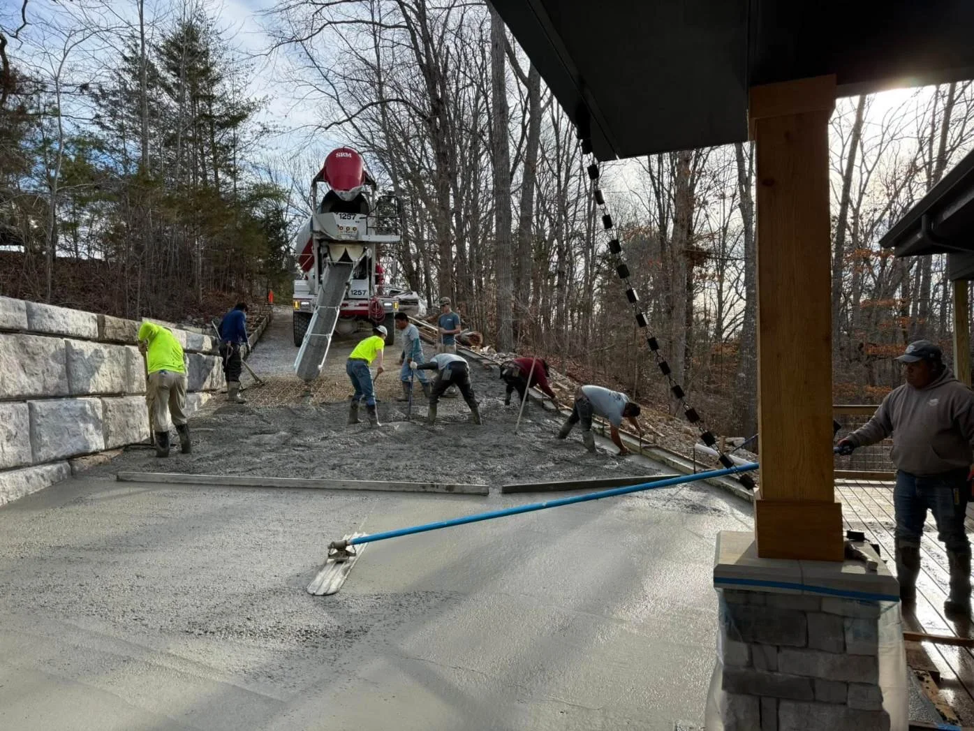 Crew pouring and finishing concrete driveway with curbs using boom pump Rock Island TN
