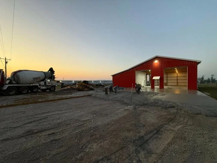 Gillespie Concrete crew pouring a 6,500 square foot concrete slab for a new volunteer fire hall at sunset