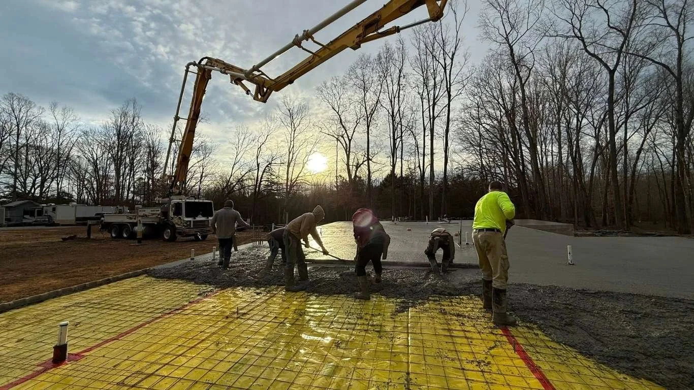 Crew pouring concrete slab over rebar mesh with boom pump Liberty TN