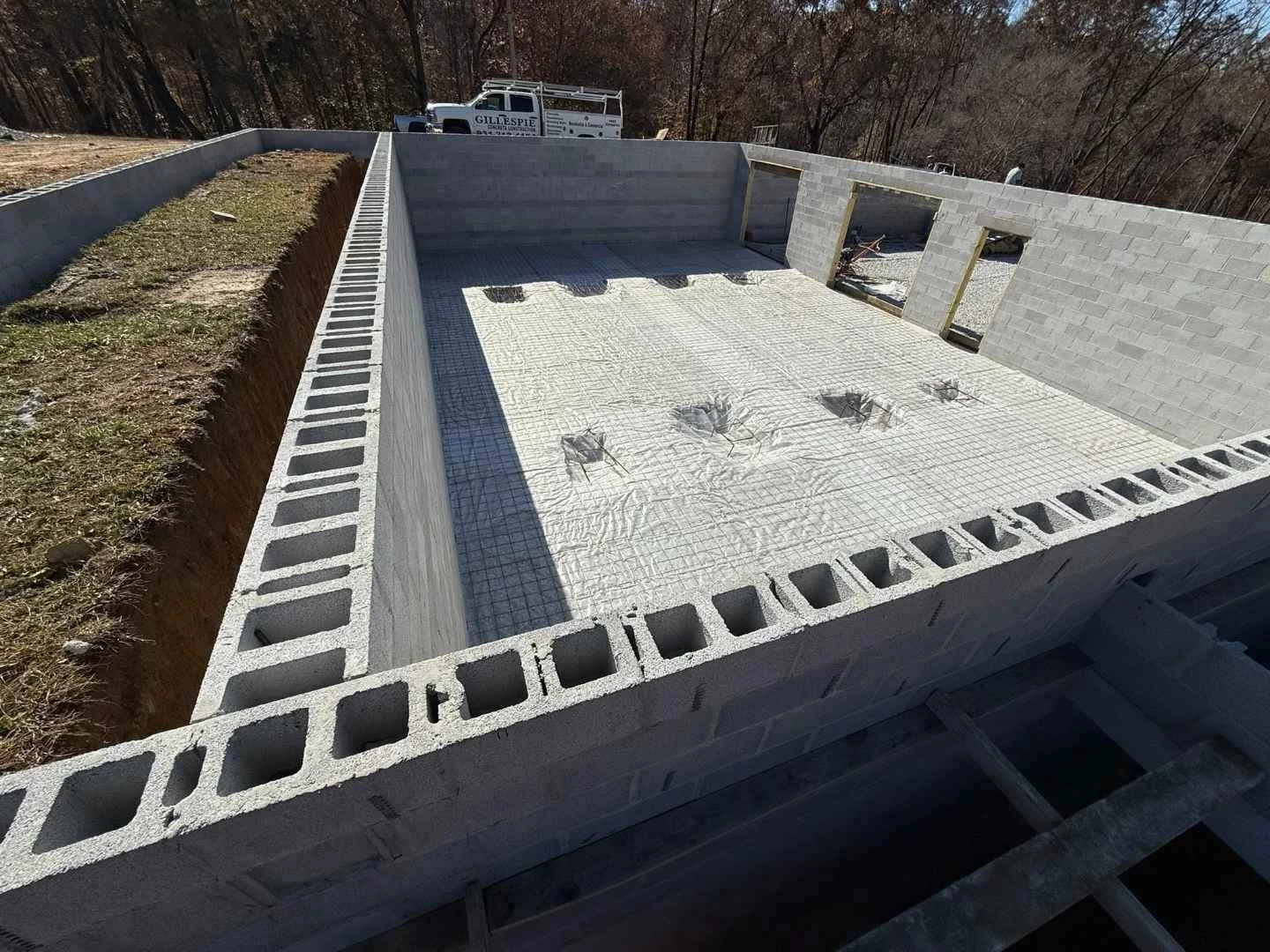 Block foundation walls with vapor barrier and rebar chairs ready for basement slab pour
