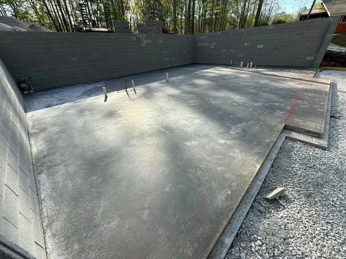 Finished basement slab inside block foundation walls with plumbing rough-ins