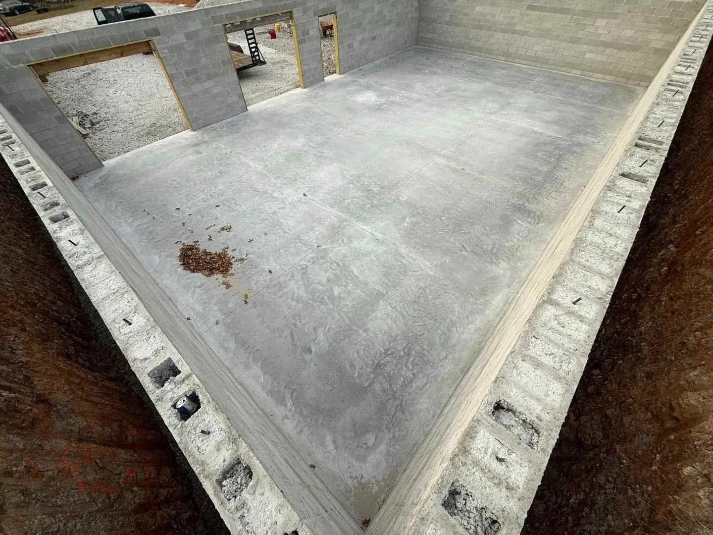 Finished basement slab foundation inside block walls with rough openings for doors