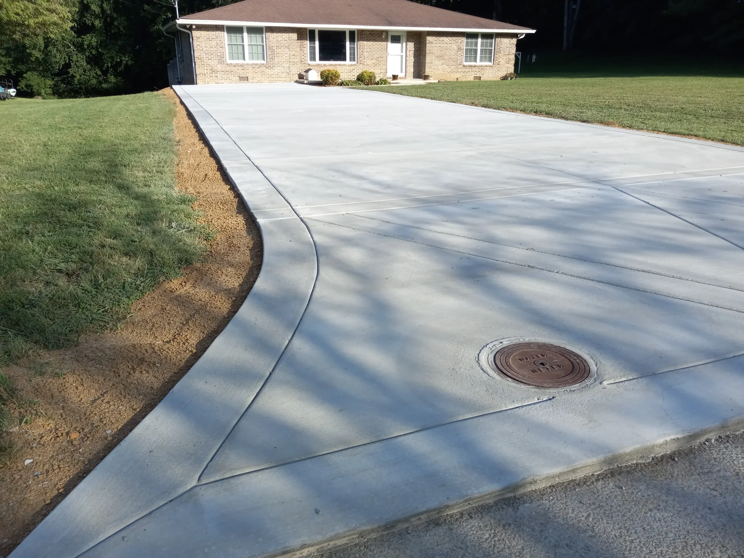 Finished decorative concrete driveway in Manchester TN with custom design and smooth surface installed by Gillespie Concrete Construction.