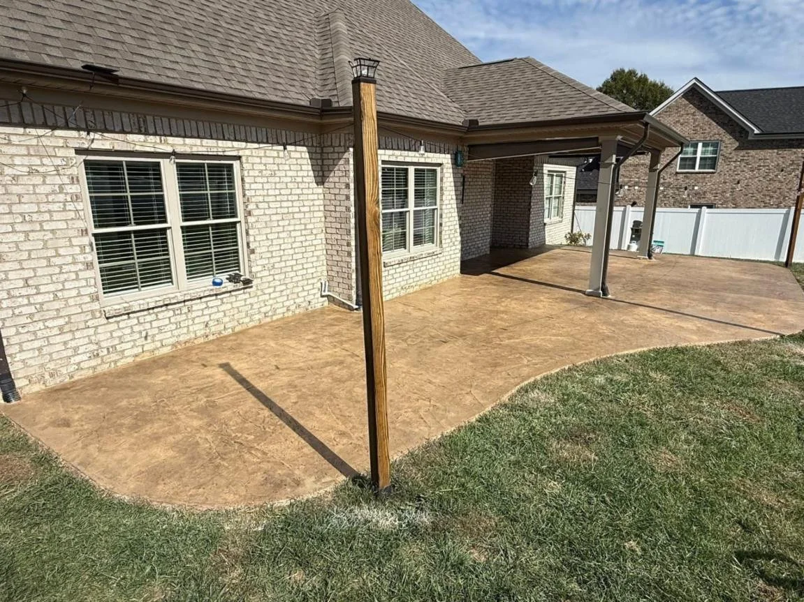 Curved concrete patio with rounded edge wrapping around a covered lakefront porch, finished smooth and ready for outdoor furniture and lake views.