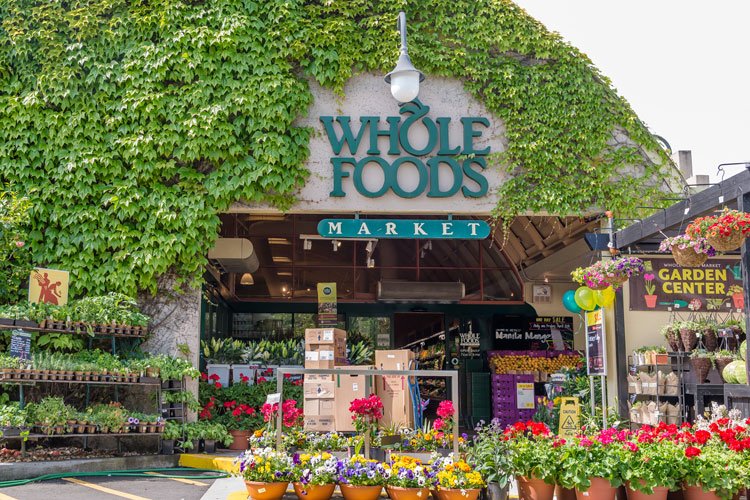 Exterior of Whole Foods Market with plants and flowers outside.