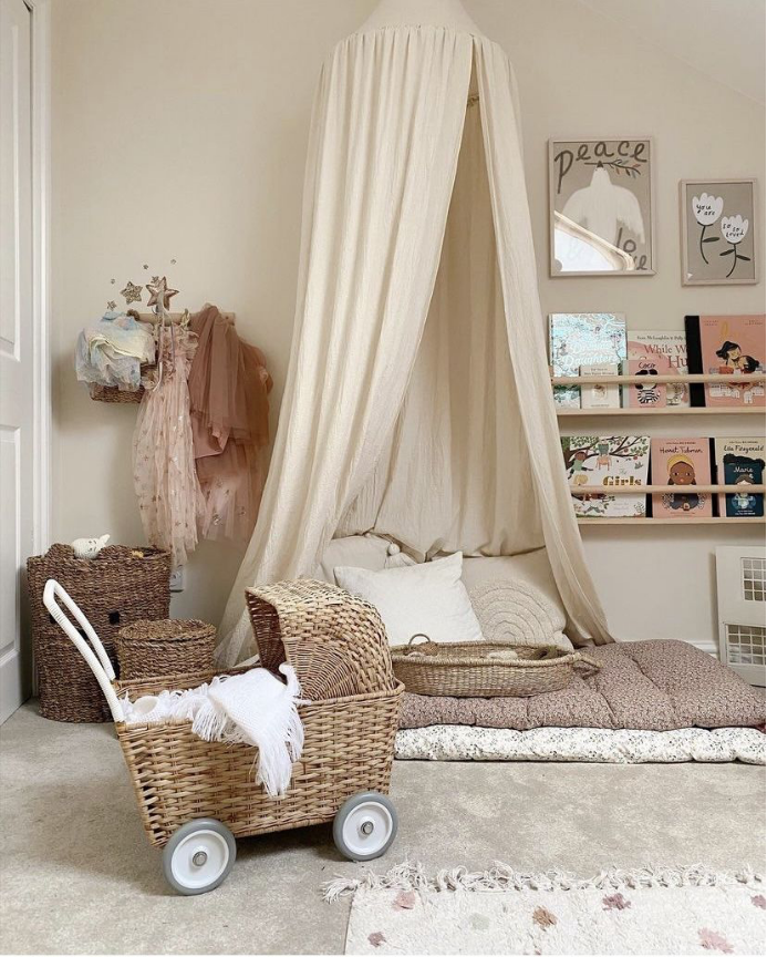 Children’s bedroom with a cream canopy, woven accents, and soft neutral textiles
