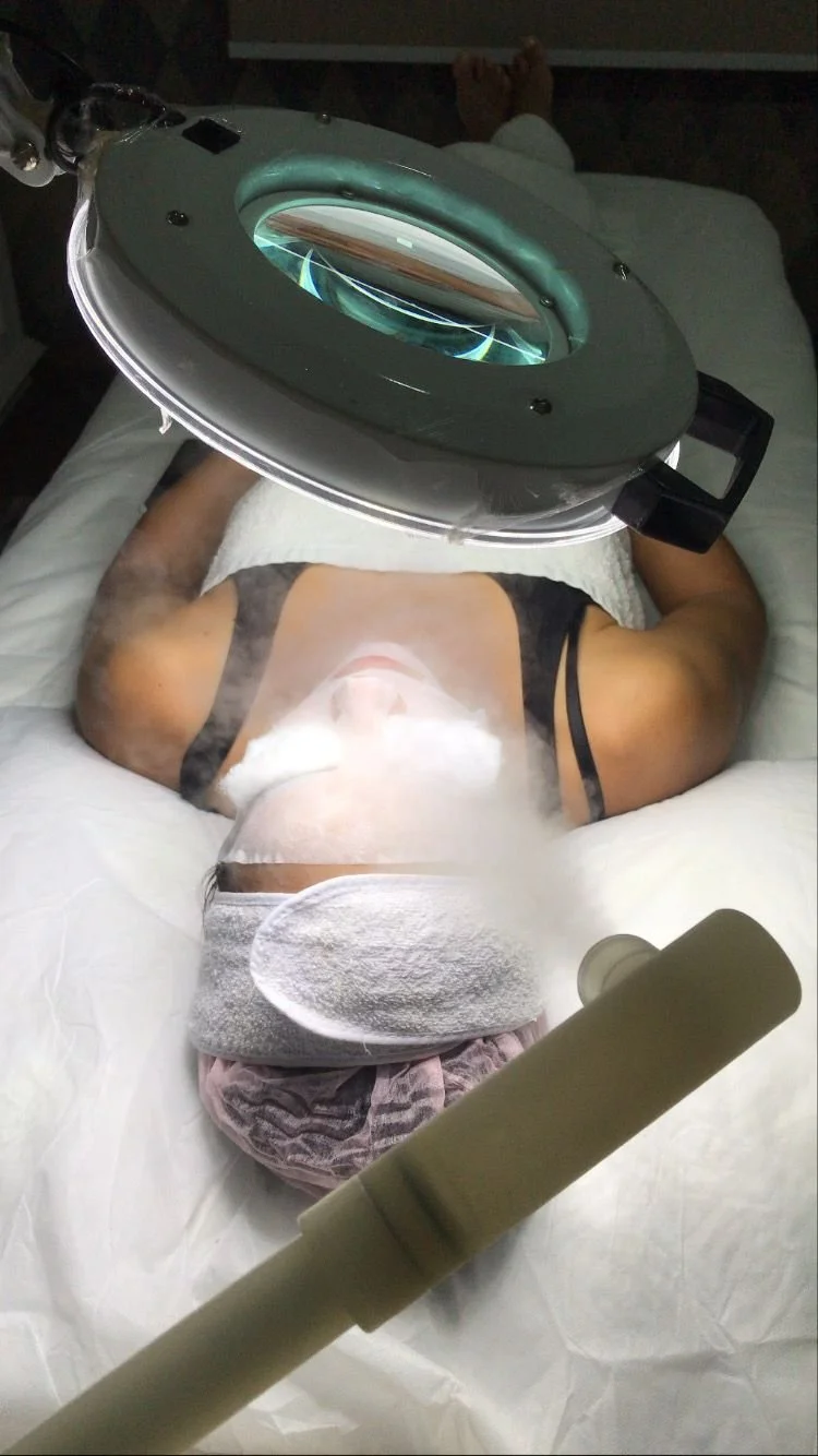 Person lying on a medical bed under an imaging machine, preparing for a scan.