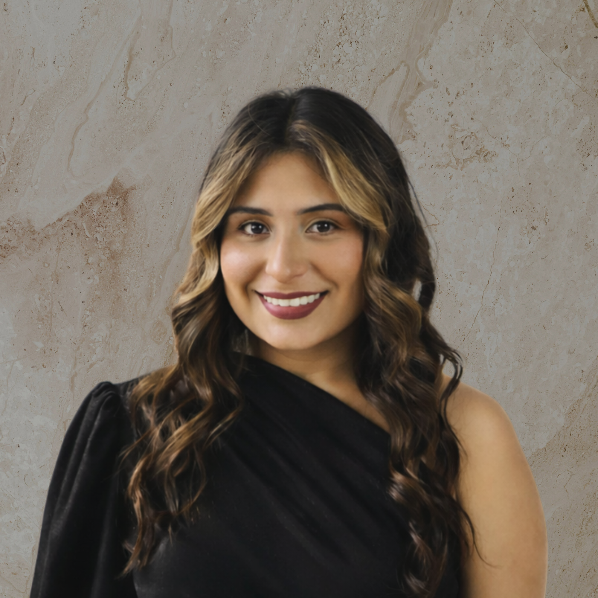 Close-up of a smiling woman with curly hair, wearing a black top, against a textured beige background.
