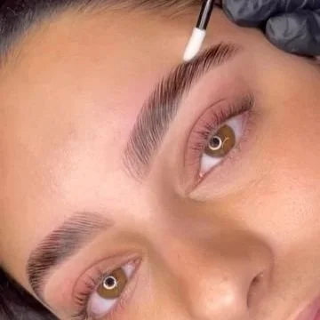Close-up of a person's face showing fresh eyebrow tinting or microblading.