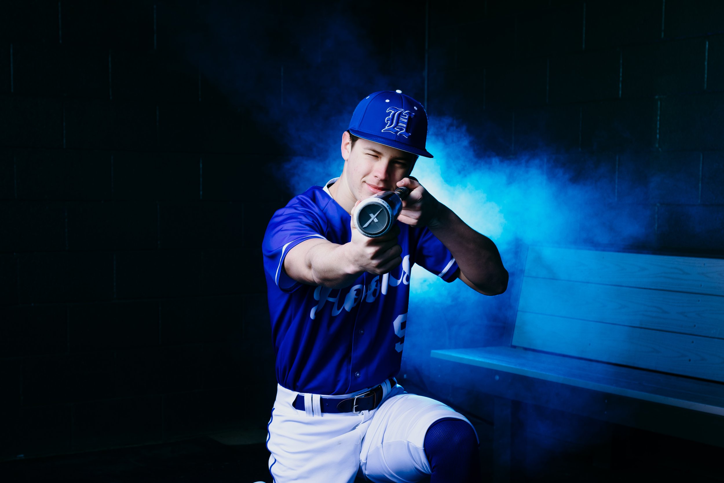 Baseball player standing confidently under colored lights for sports photo session