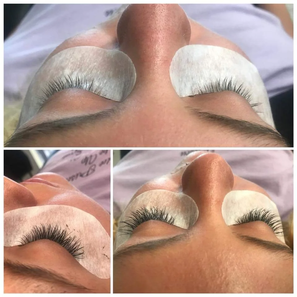 Close-up of a person receiving eyelash extension treatment, lying on their back with eyelash pads under each eye.