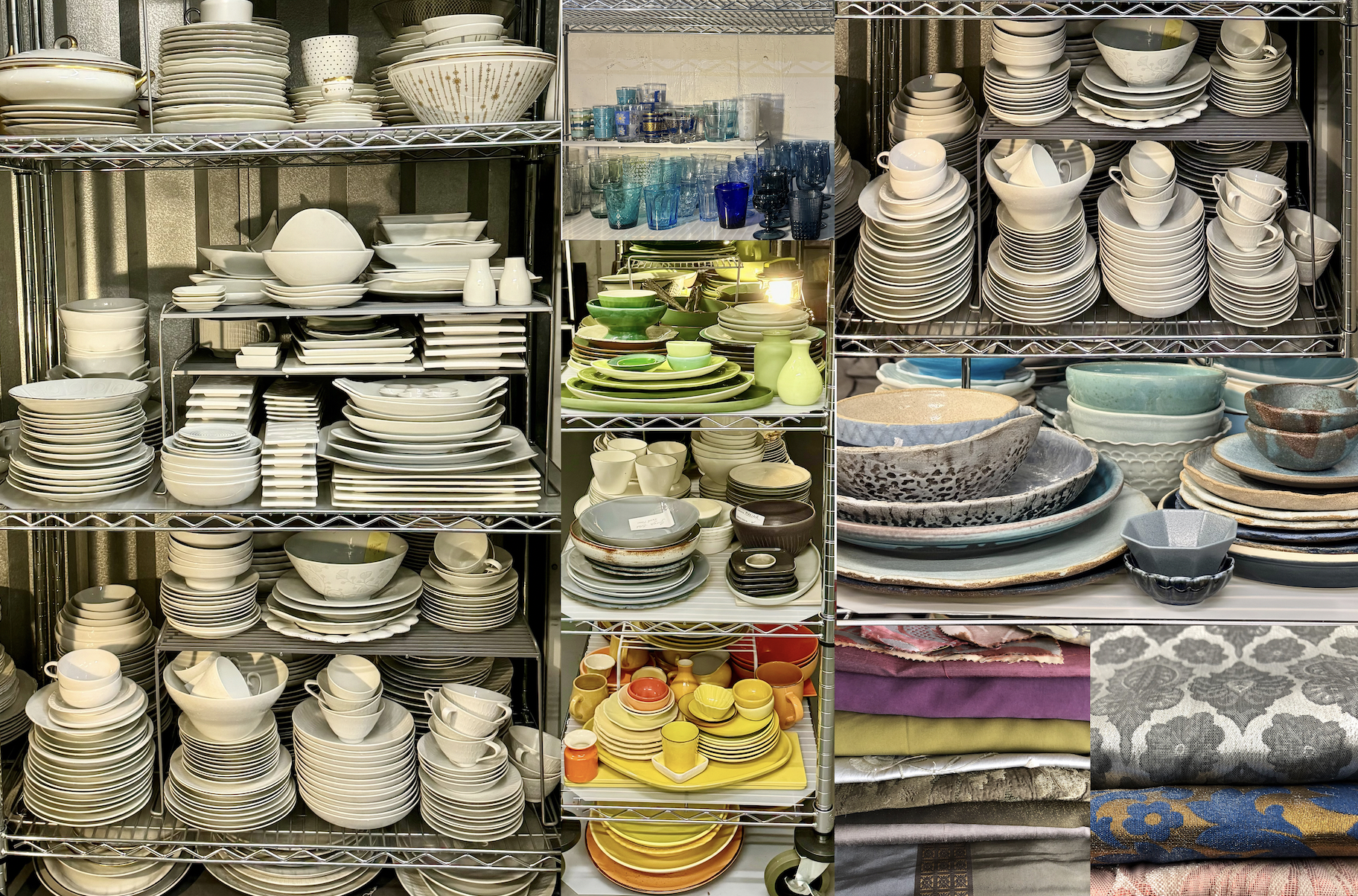 A shelving unit filled with various stacks of dinnerware, including plates, bowls, glasses, cups, and sets of colorful dishware and cloth napkins, organized on metal racks with some items on wheels.