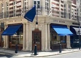 Exterior view of the David Messum gallery with blue awnings and a corner location