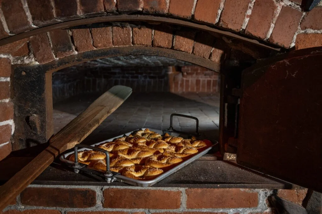 Pizza with cheese and pepperoni baking in a brick oven.