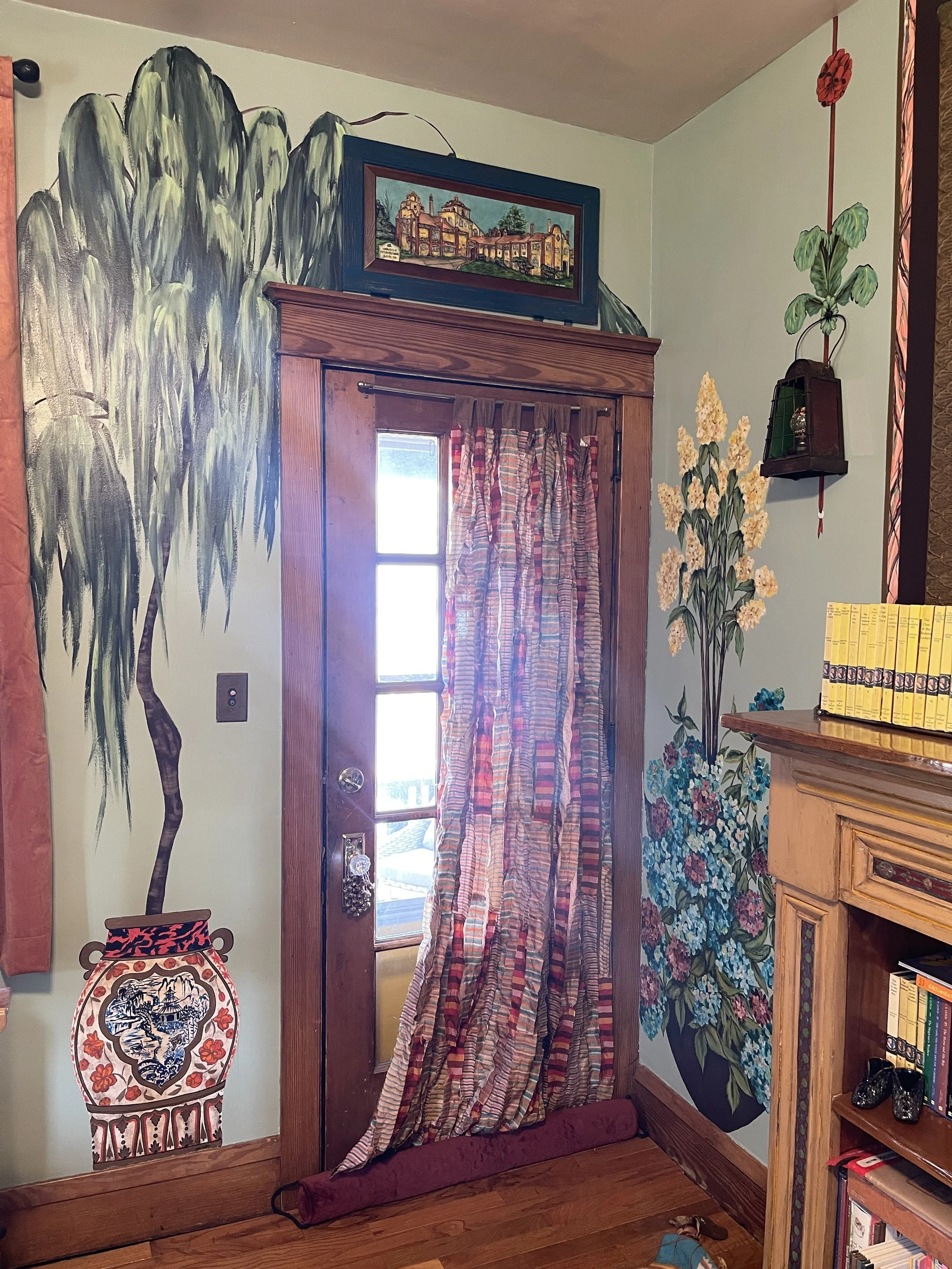 Interior hand painted mural on living room walls of a dramatic floor-to-ceiling willow tree in an asian-inspired antique porcelain vase surrounded by painted hydrangeas, by artist Sara Trotter / Chroma Maison Design.
