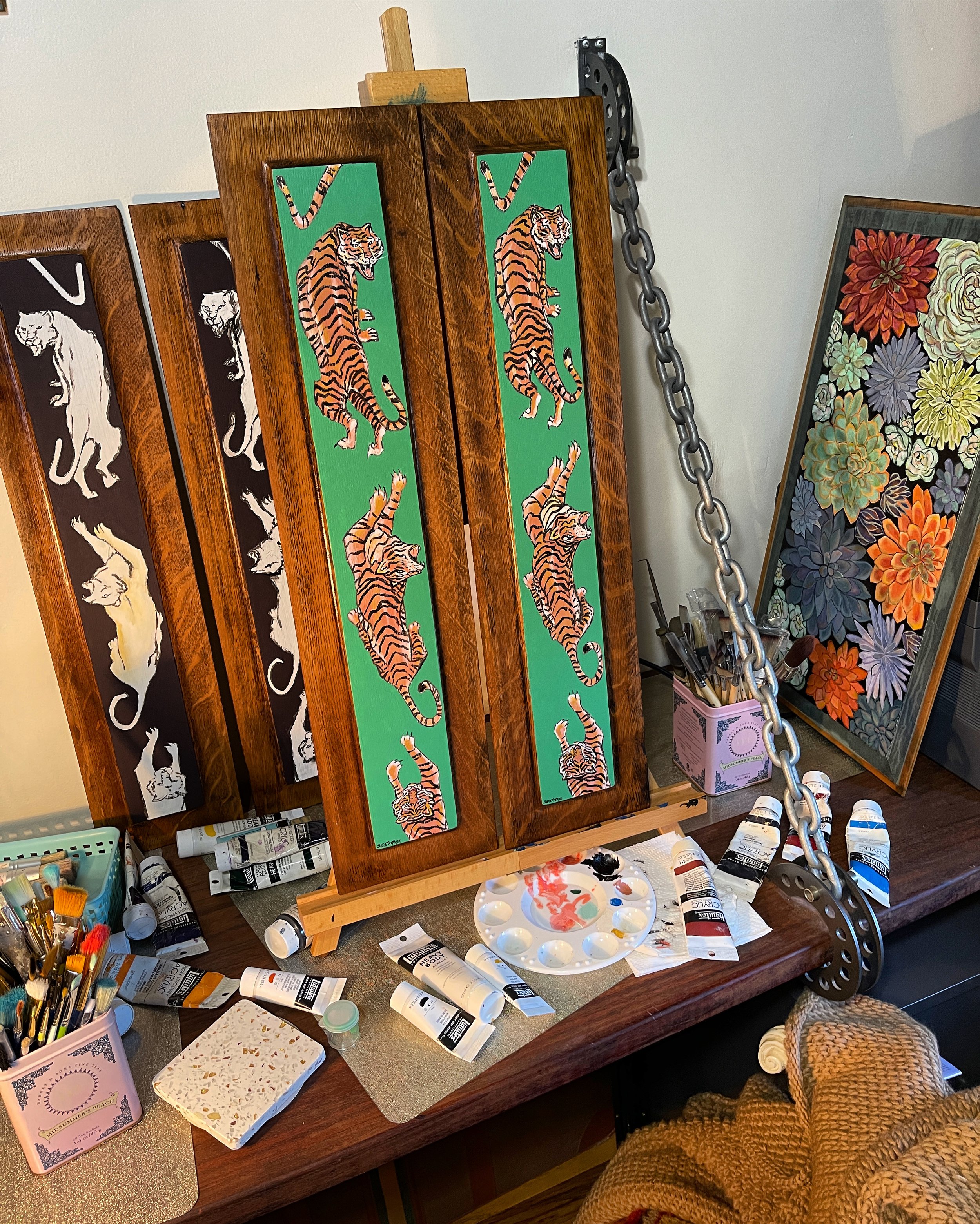 Studio space at Chroma Maison Design featuring in-progress tiger painted panels at a desktop easel, by Sara Trotter / Chroma Maison Design.