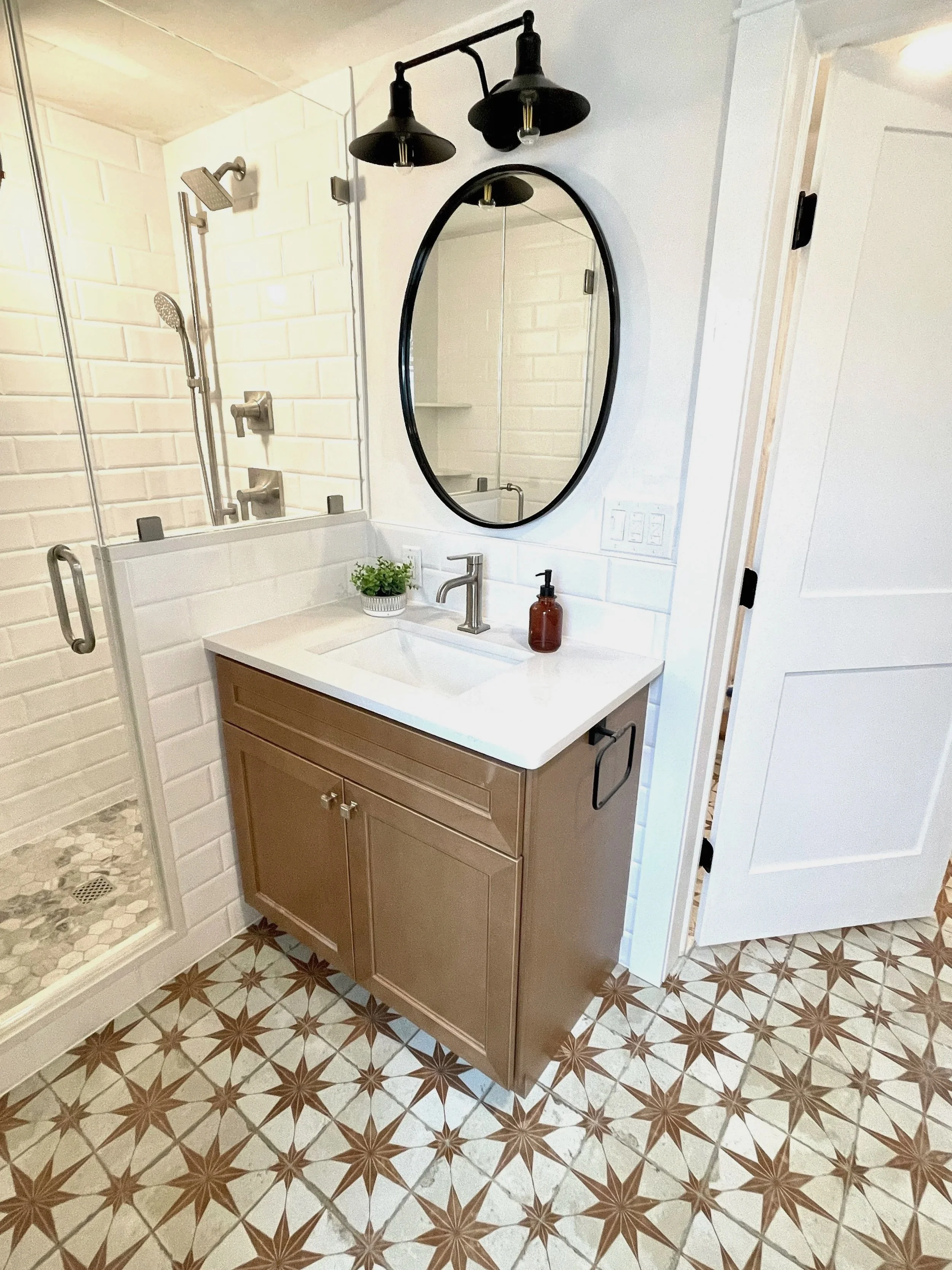 Star oxide pattern floor tile in a hall bath with black farmhouse lanterns overhead, designed and photographed by Sara Trotter / Chroma Maison Design.