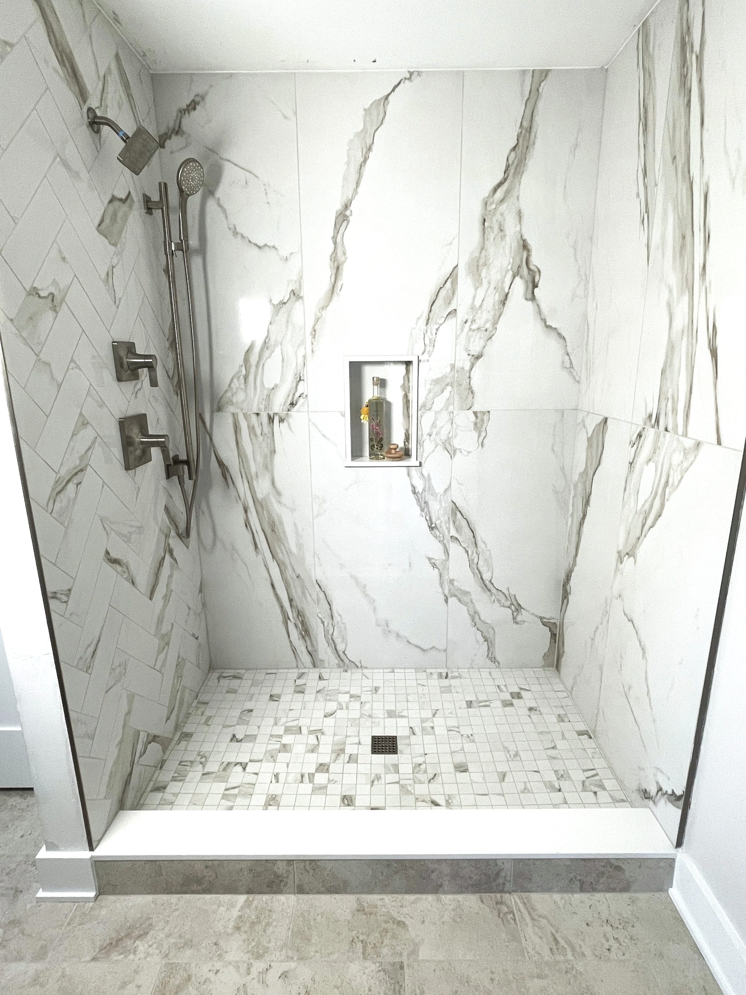 Porcelain large format Calacatta marble shower with herringbone accent plumbing wall, designed and photographed by Sara Trotter / Chroma Maison Design.