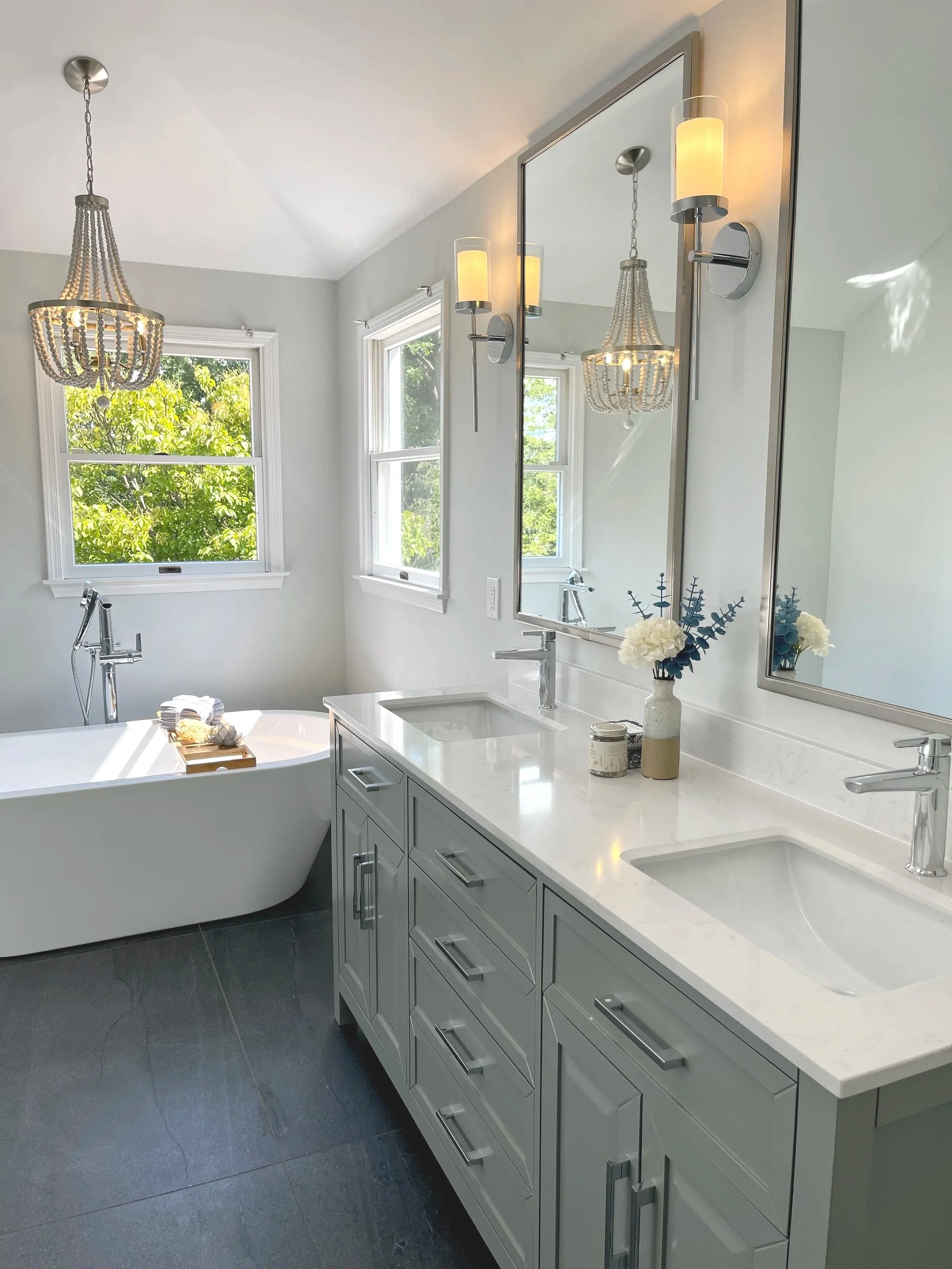 Coastal charm bathroom with a bohemian beaded chandelier above a freestanding tub, designed and photographed by Sara Trotter / Chroma Maison Design.