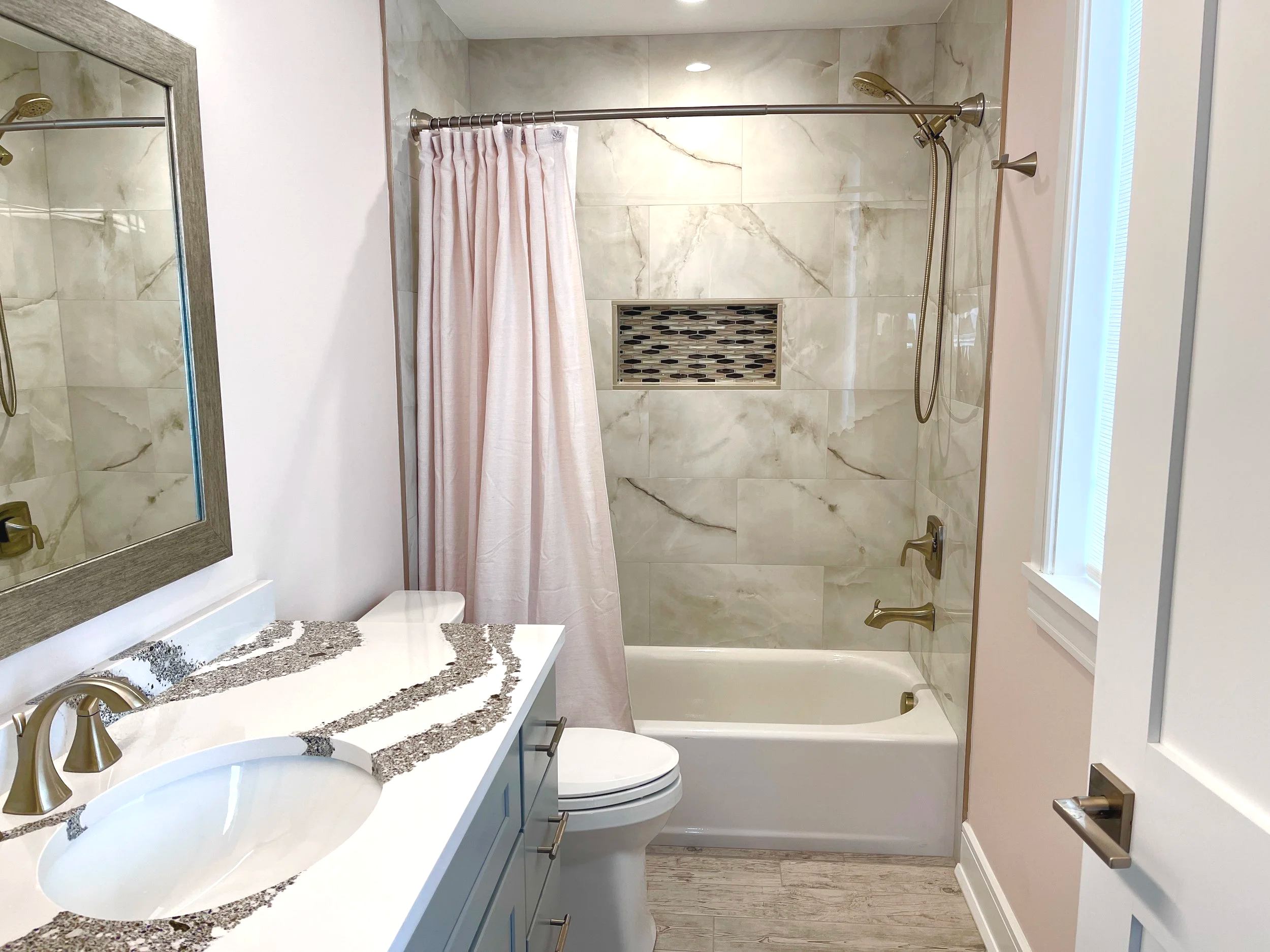 Onyx bathroom with blush wall paint and matching shower curtain.  Countertop is Cambria Annicca quartz with rich sparkling purple and gold crushed mica in the veining, designed and photographed by Sara Trotter / Chroma Maison Design.