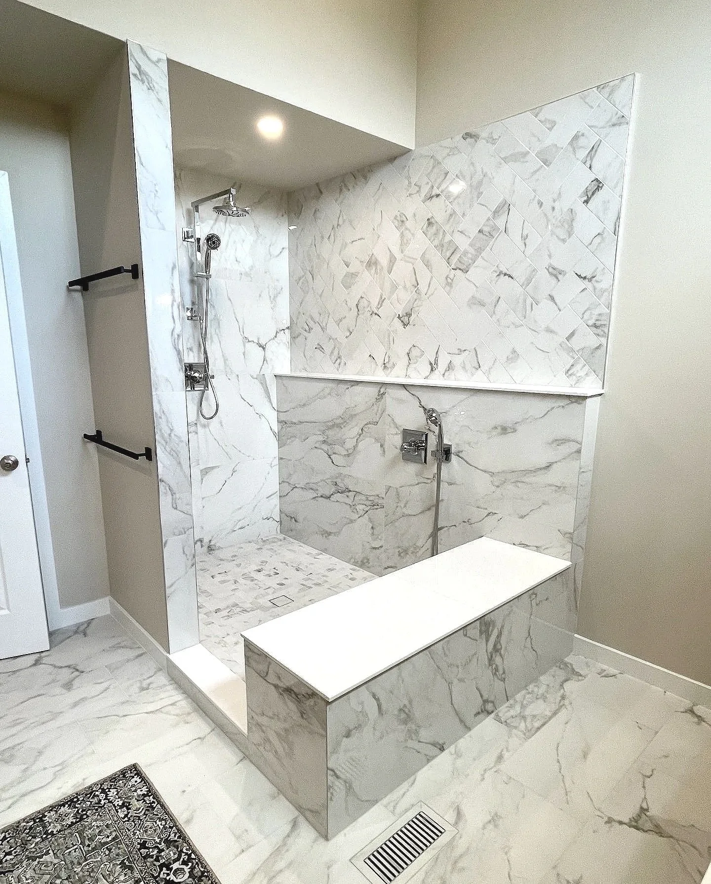 This is so in right now!  A primary shower with a large bench and full length product ledge wall, designed and photographed by Sara Trotter / Chroma Maison Design.