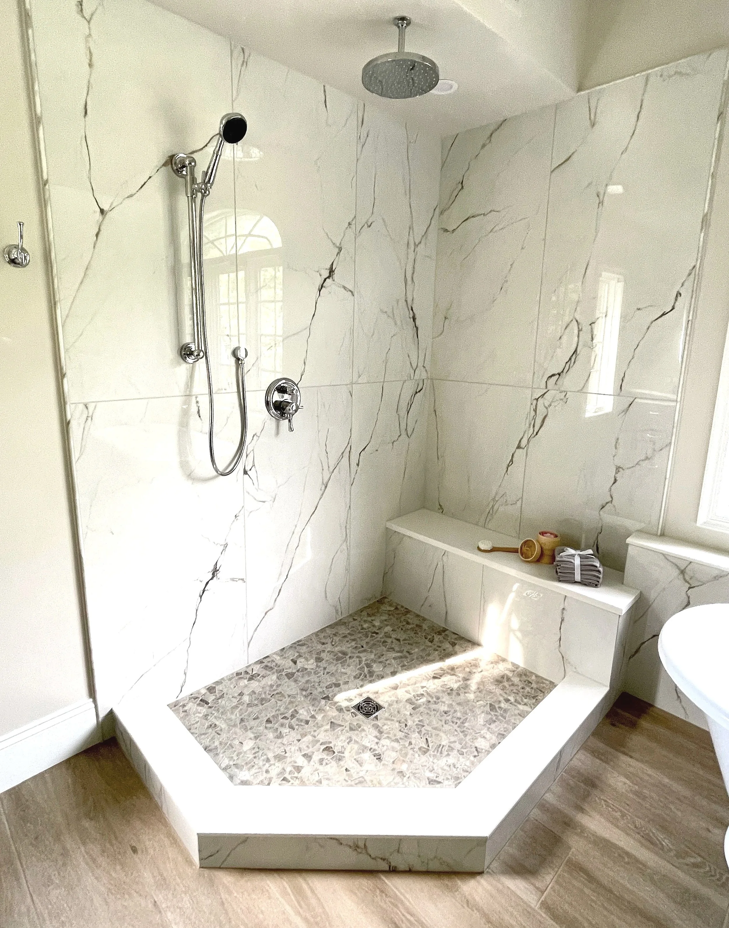 Large format porcelain marble corner shower with bench and rain shower head, designed and photographed by Sara Trotter / Chroma Maison Design.