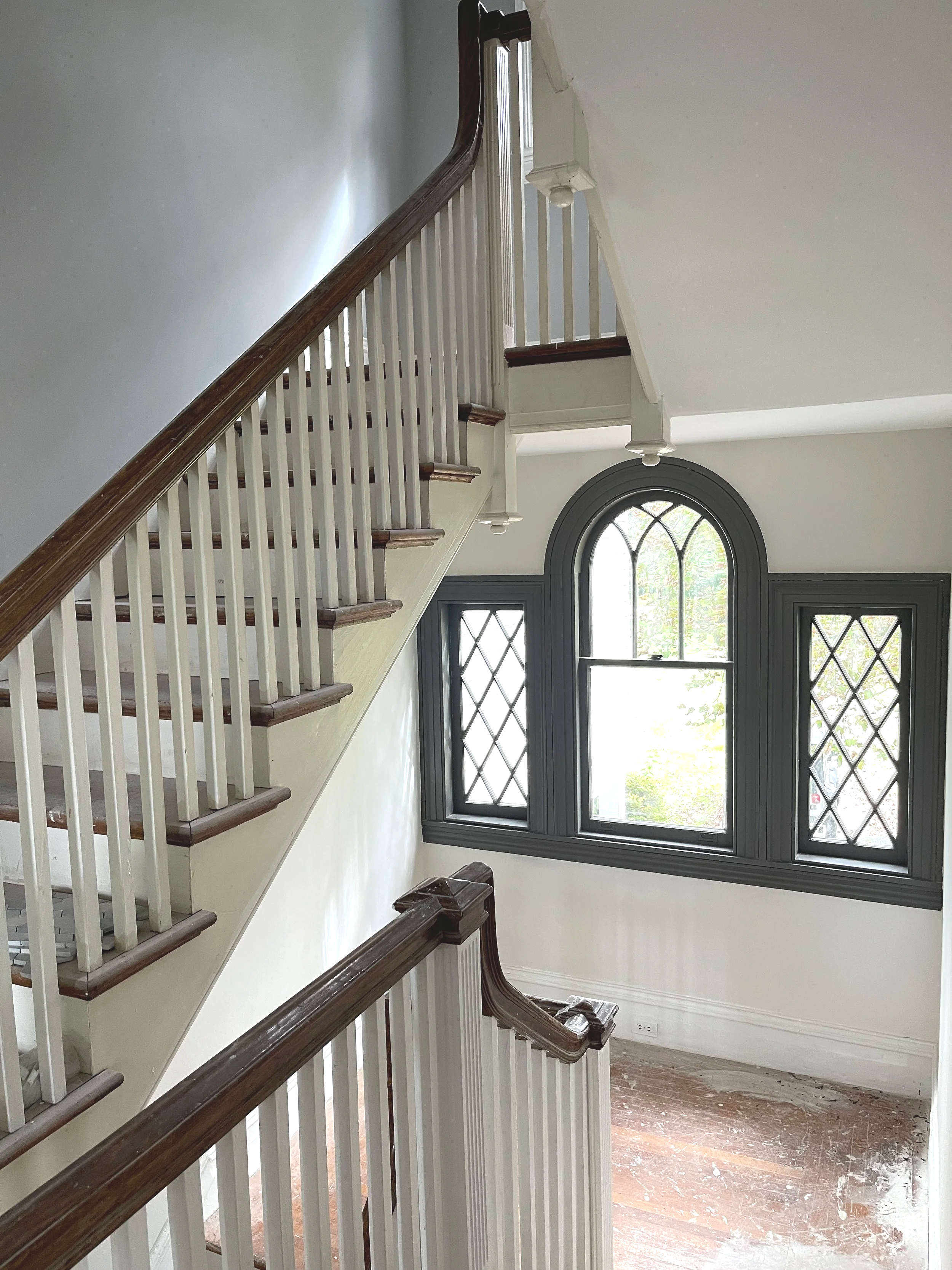A historic Blue Bell mansion in the process of being renovated for resale.  The original three leaded glass picture windows in the stairwell feature Kendall Charcoal painted accent color.  Custom paint plan by Sara Trotter / Chroma Maison Design.