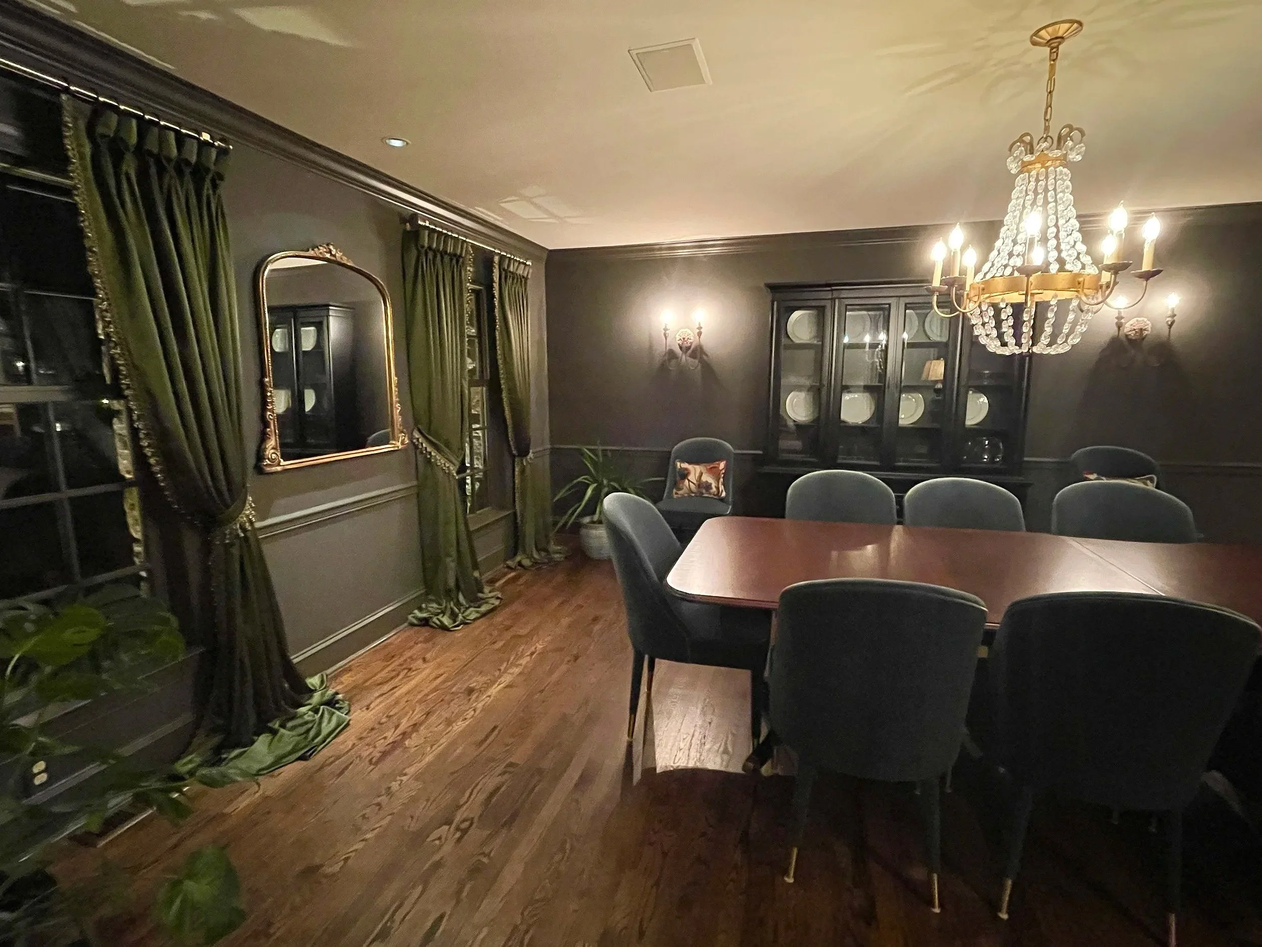 Moody color drenched dining room in Urbane Bronze paint with rich velvet green floor length curtains.  Custom paint plan and photography by Sara Trotter / Chroma Maison Design.