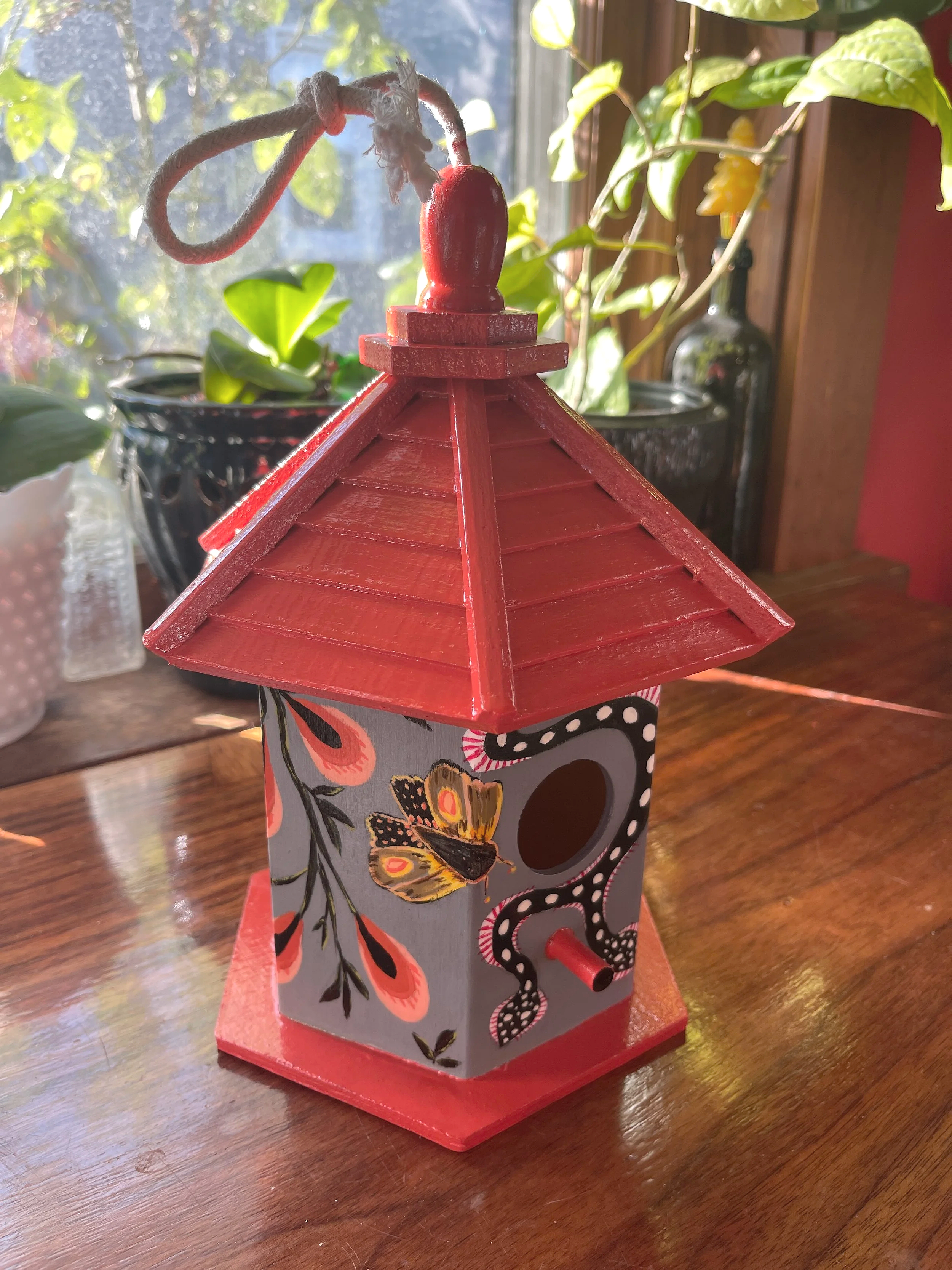 Painted wood birdhouse with red roof and pattern snake, painted by Sara Trotter.