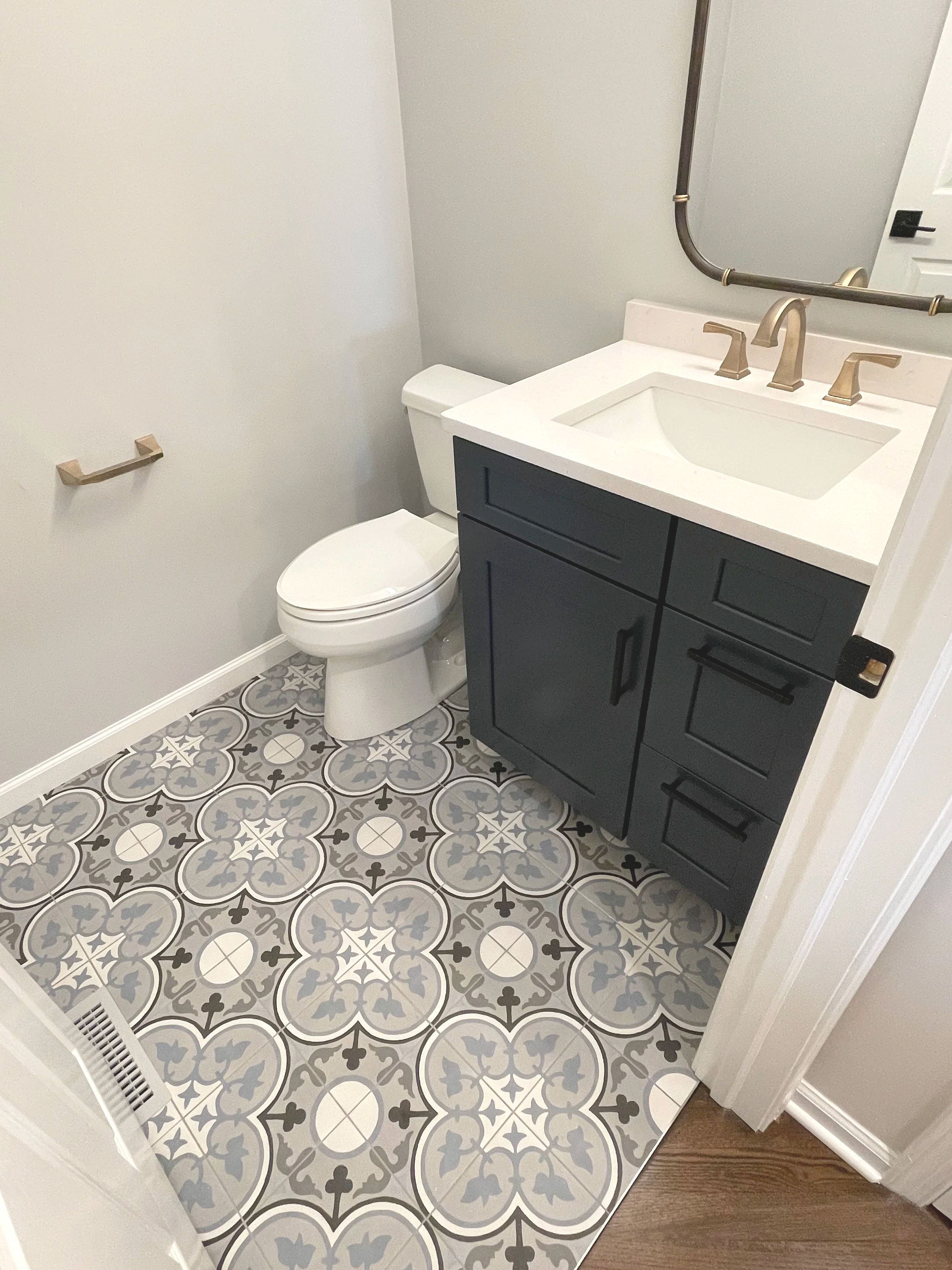 Dal Tile blue pattern tile powder room floor paired with a navy vanity, designed and photographed by Sara Trotter / Chroma Maison Design.