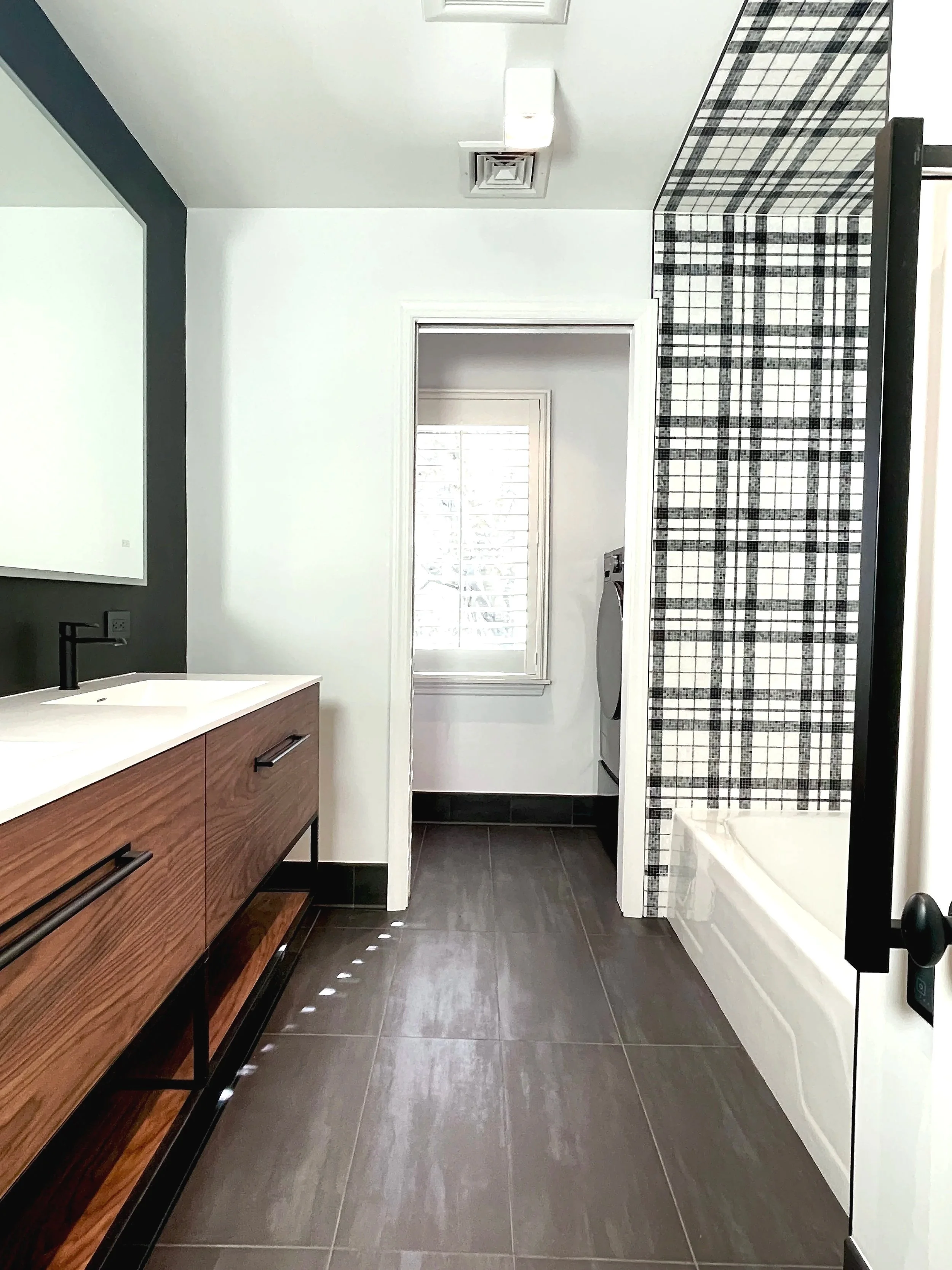 Stunning hall bath with black and white marble plaid tiled tub walls, designed and photographed by Sara Trotter / Chroma Maison Design.