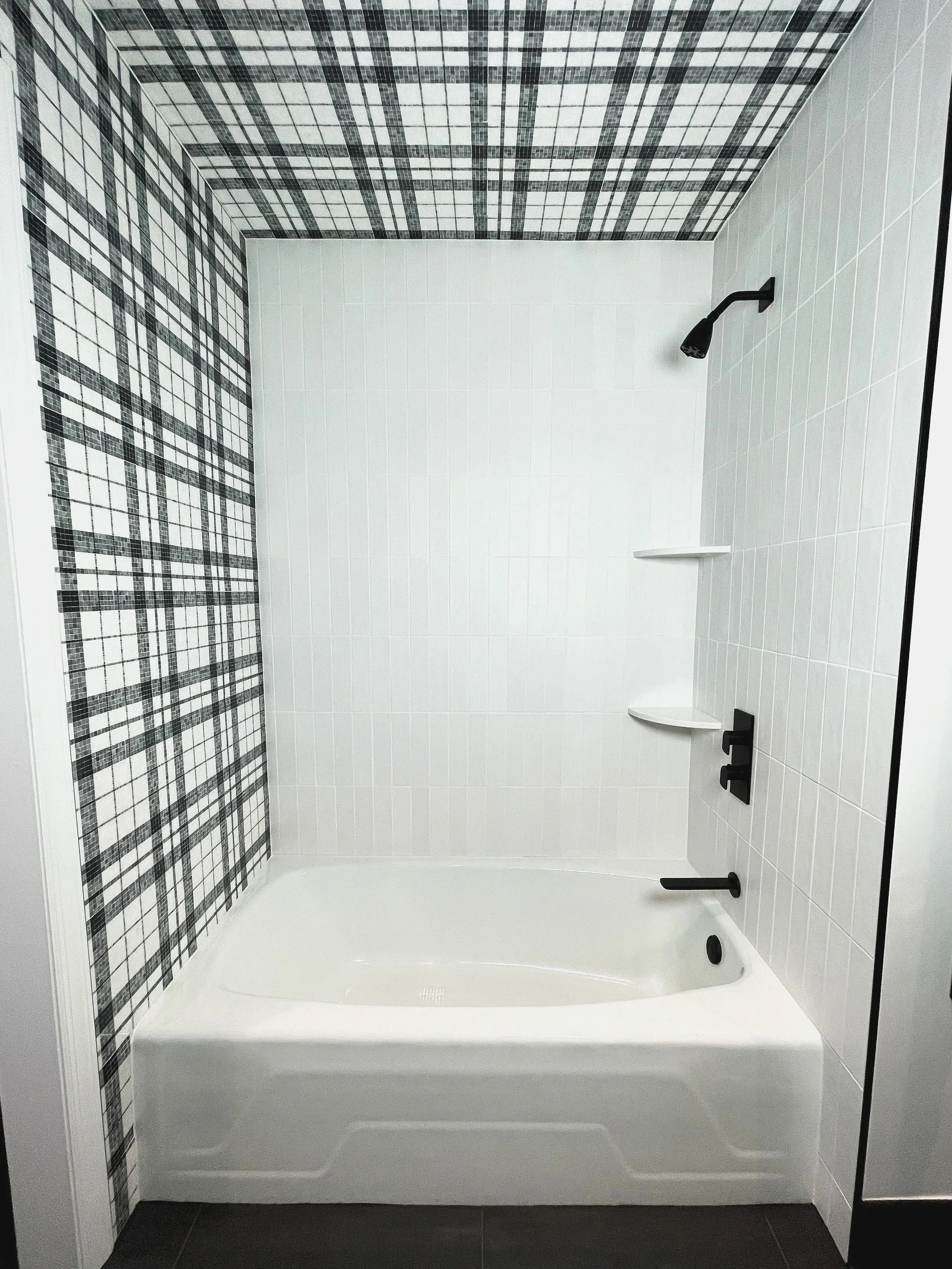 Now this is a unique shower wall!  Black and white marble plaid mosaic tiled tub walls, designed and photographed by Sara Trotter / Chroma Maison Design.