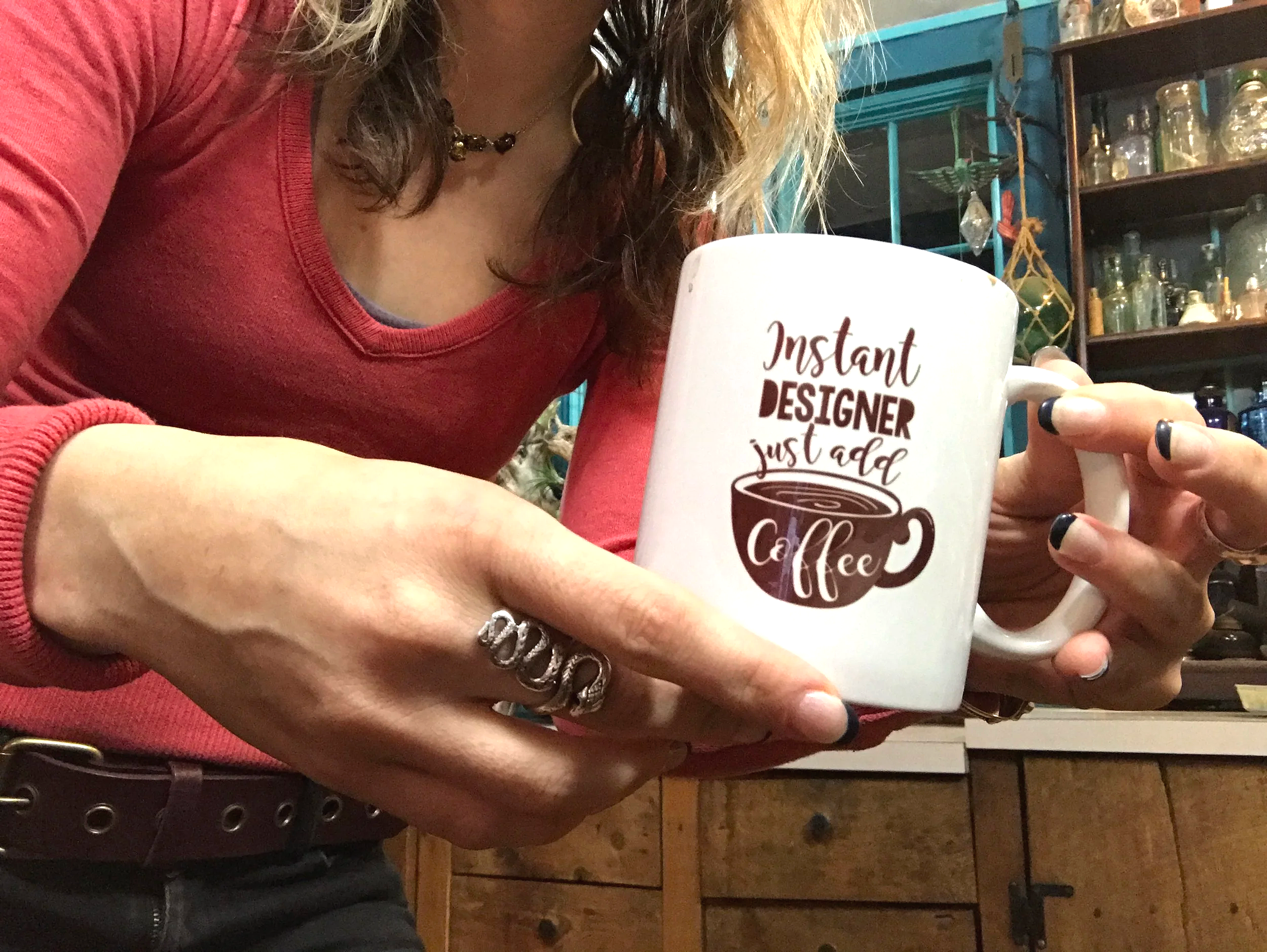 Artist Sara Trotter holding a mug that says "Instant Designer just add coffee," photography by Chroma Maison Design.