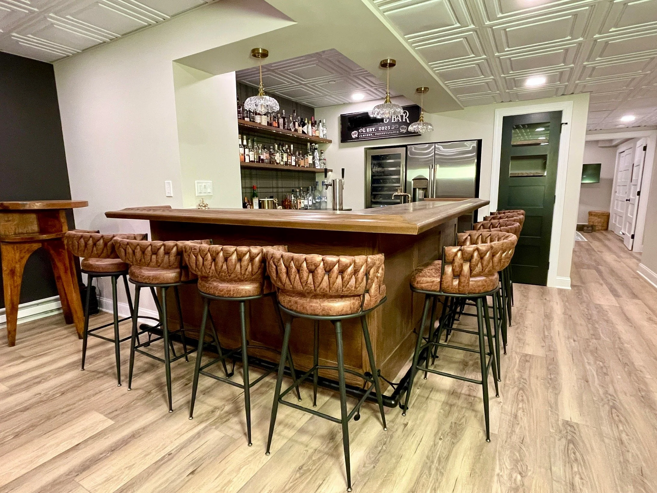 Basement renovation with a custom walnut bar, vintage glass pendant lights, and charcoal plaid wallpaper, designed and photographed by Sara Trotter / Chroma Maison Design.