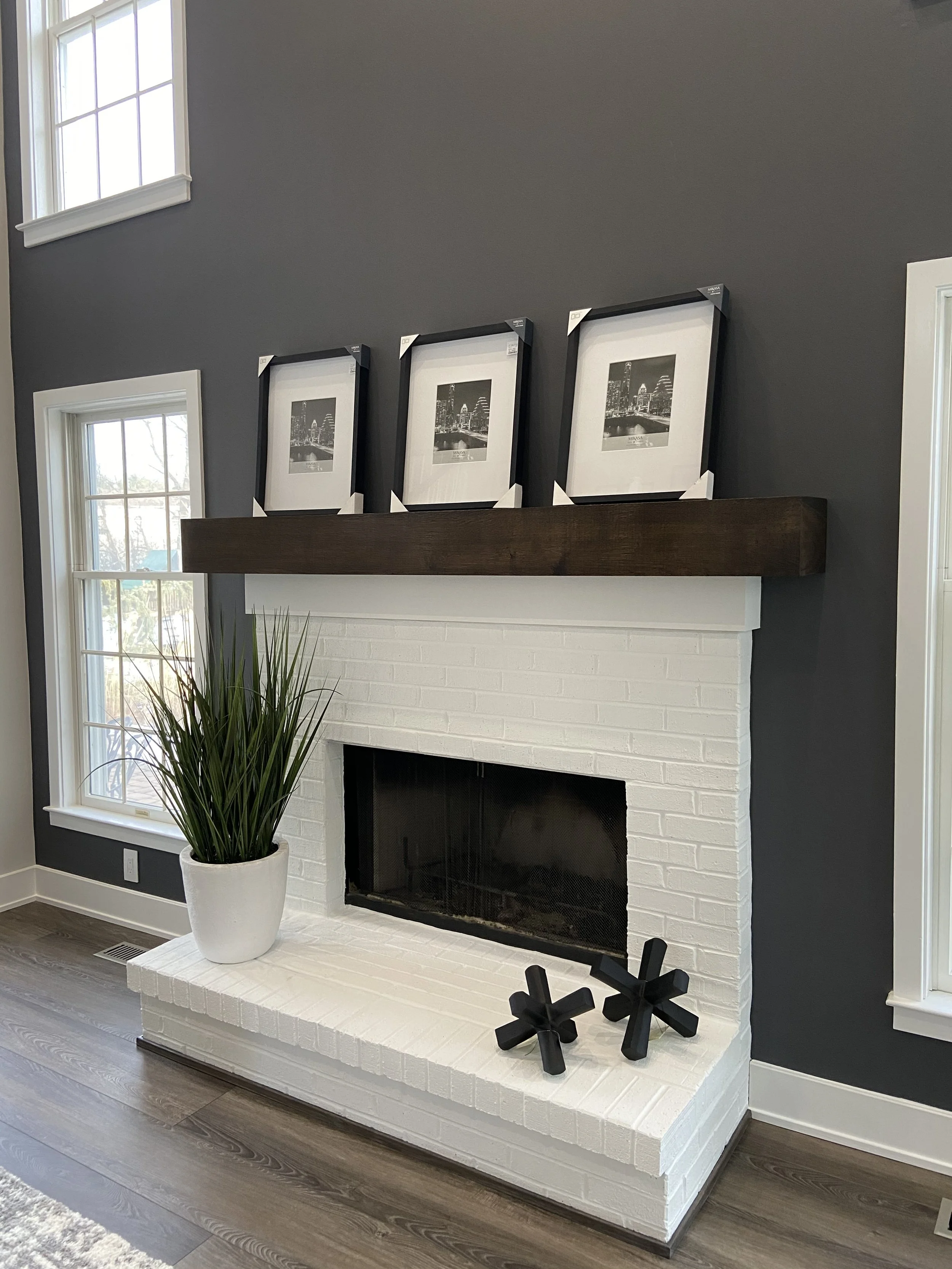 White matte painted brick fireplace surrounded by a rich deep blue accent wall.  Custom paint plan by Sara Trotter / Chroma Maison Design.