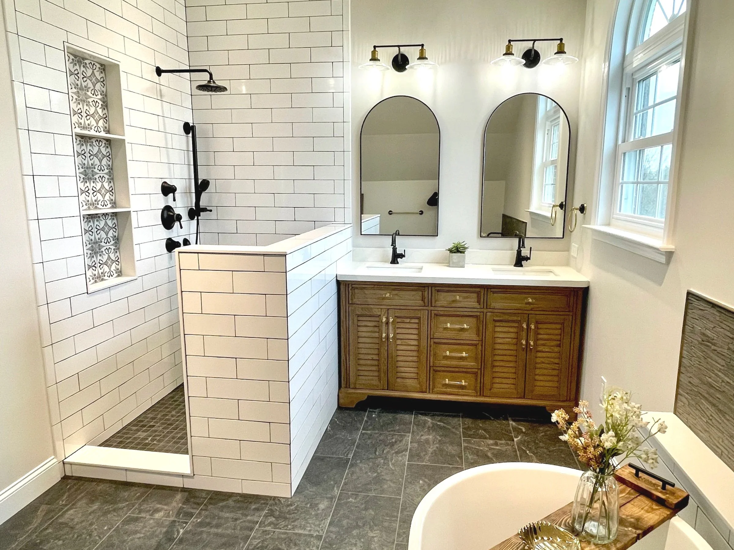Sophisticated farmhouse bathroom featuring a full shower, soaking tub, and a wood fluted vanity, designed and photographed by Sara Trotter / Chroma Maison Design.
