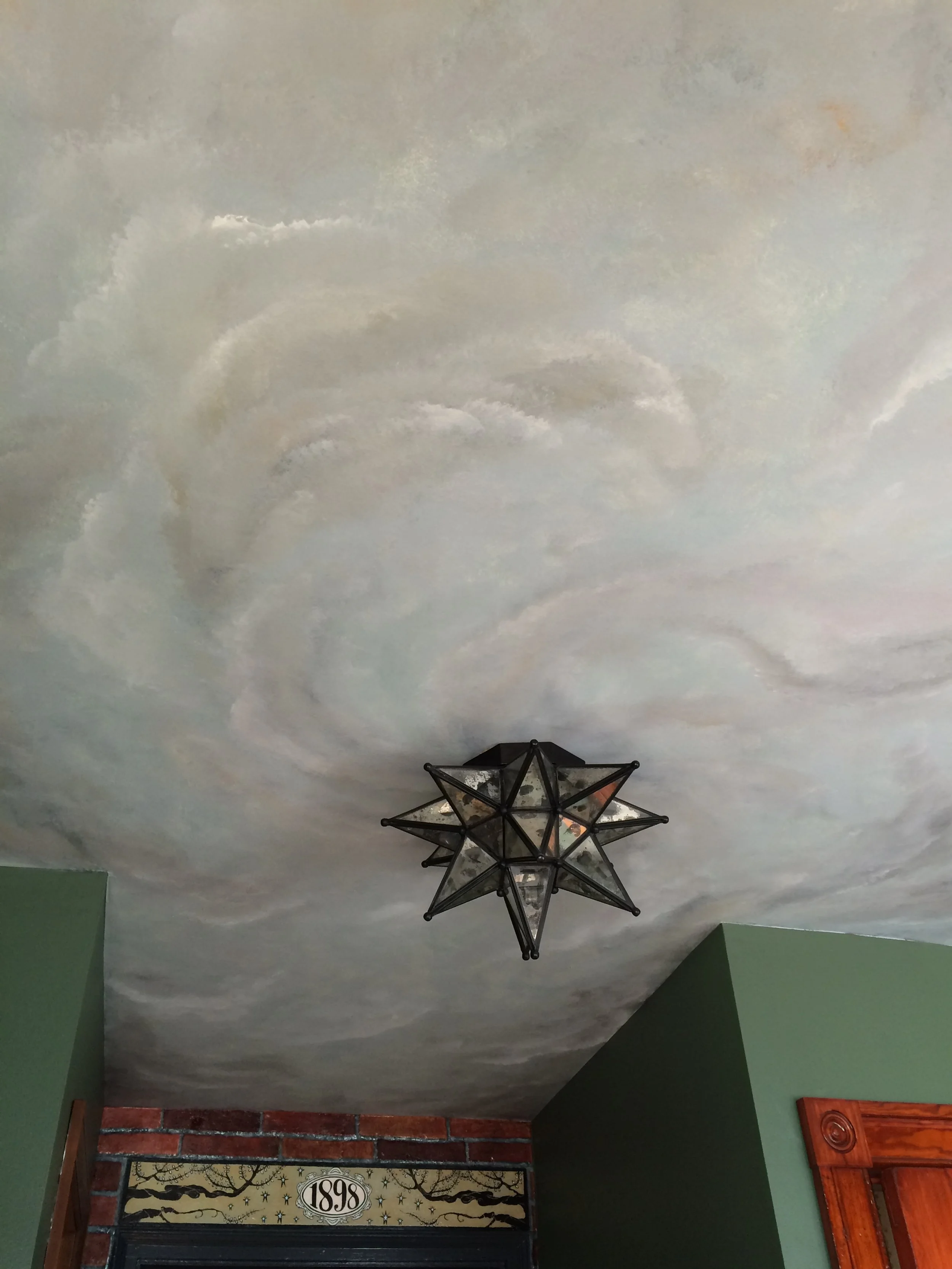 Stormy hand-painted laundry room ceiling with a Moravian Star ceiling flush-mount light centered & faux brick walls, designed and painted by Sara Trotter / Chroma Maison Design.