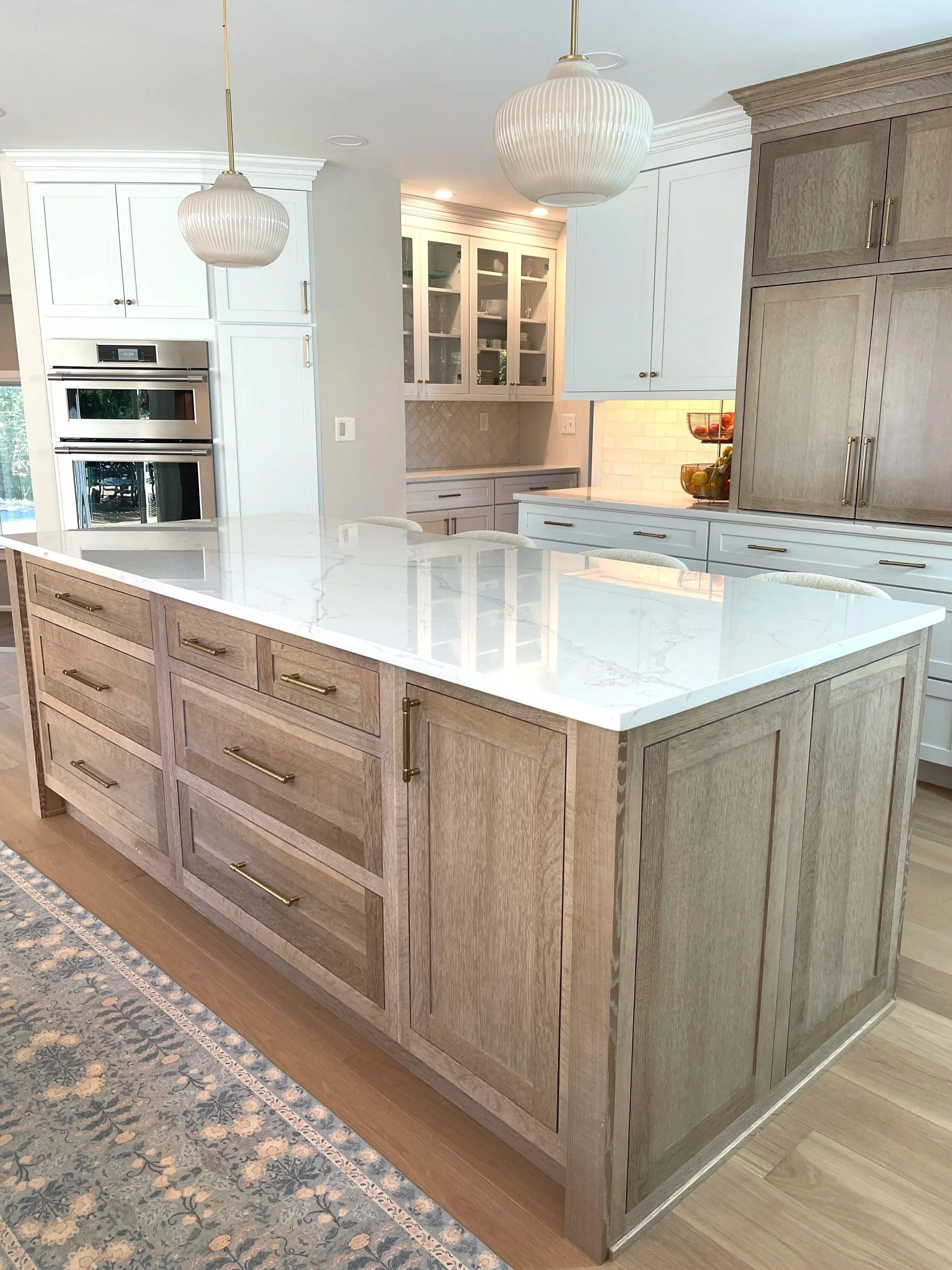 White oak Omega cabinetry kitchen island with West Elm sculptural ribbed pendant lights featured above, designed & photographed by Chroma Maison Design.