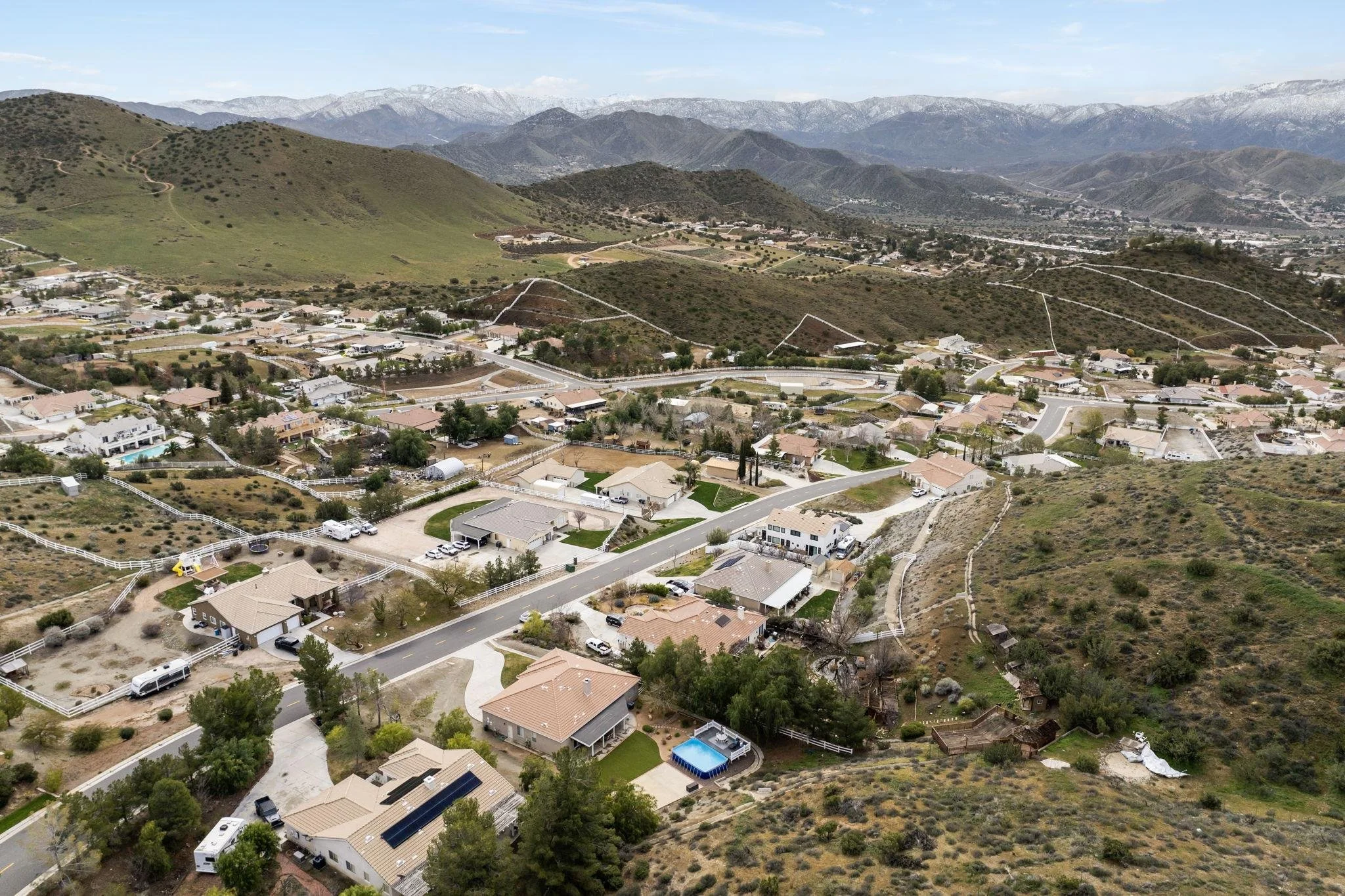 Aerial view of a master-planned residential community surrounded by hills and mountains.