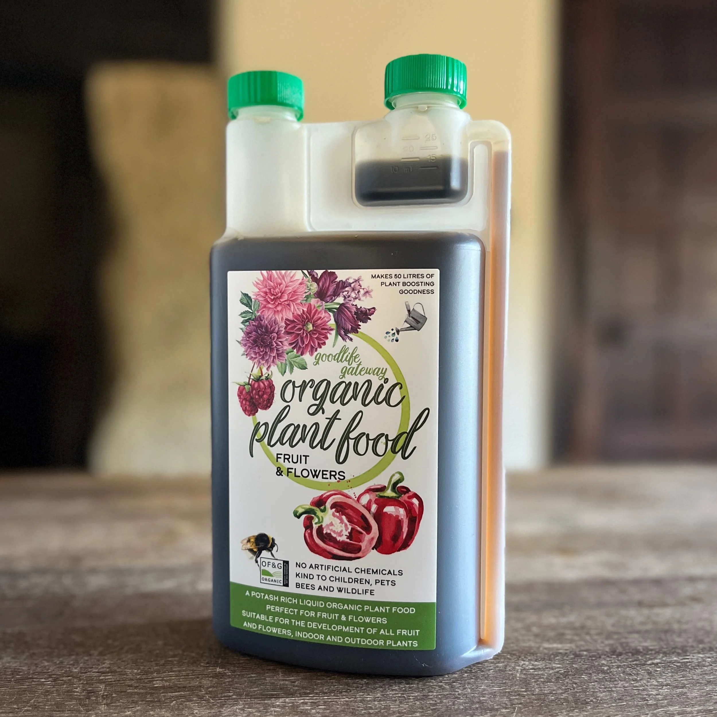 A bottle of organic plant food with a hand painted label on a wooden table