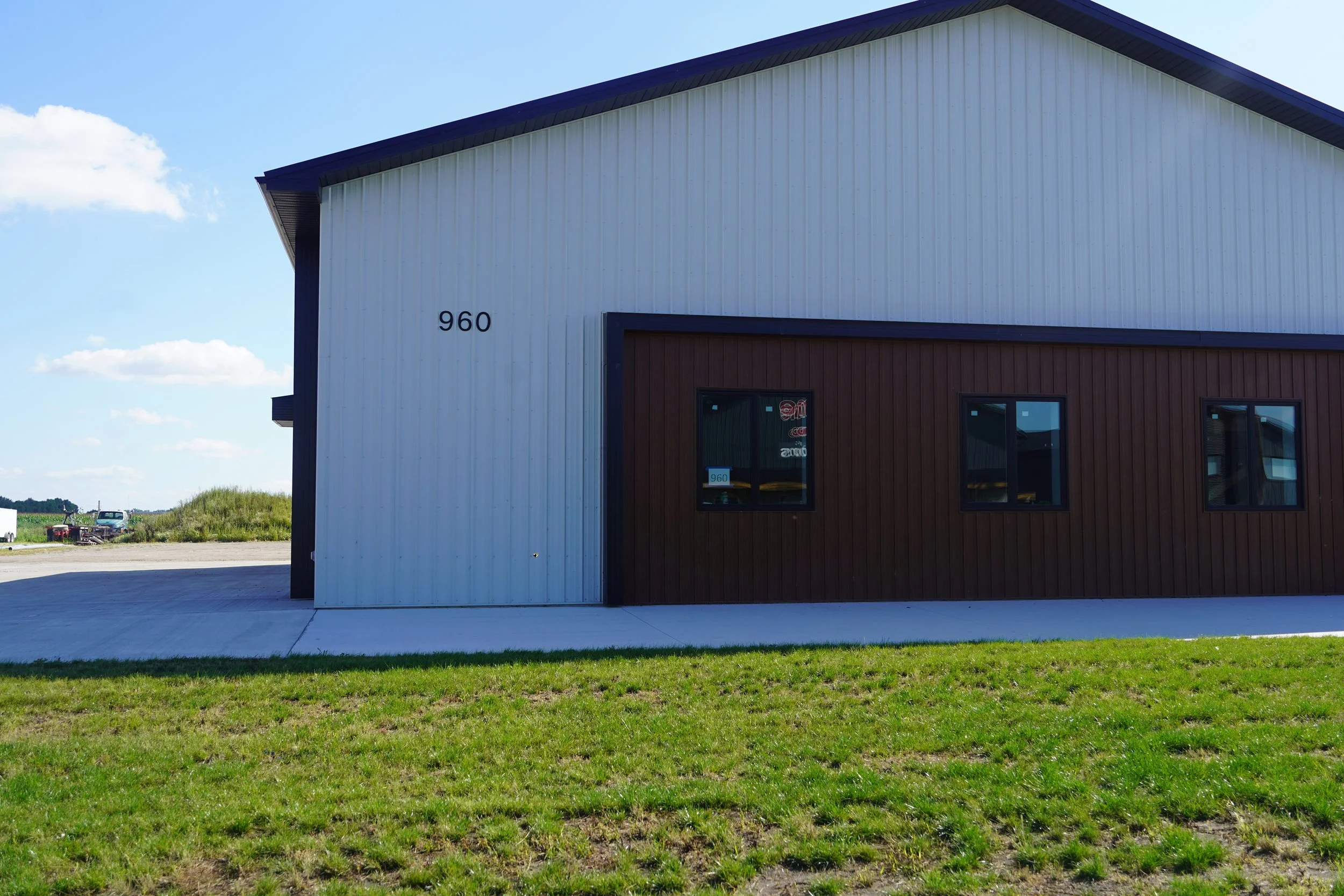 A modern building with a part white and part dark brown exterior, with the number 960 displayed on the white section, and three windows on the brown section. Hockey Training Facility, PV Elite Hockey, Mitch Dyck Performance Centre