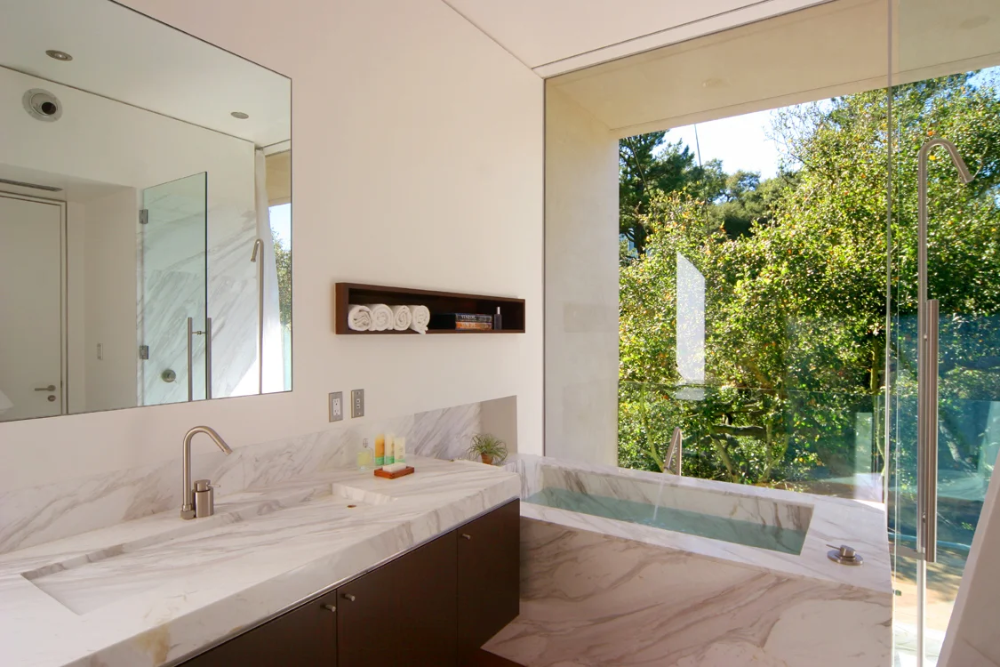 Architecture and design of residence designed to protect trees and to maximize views and breezes in Benedict Canyon. Bathroom with marble tub.