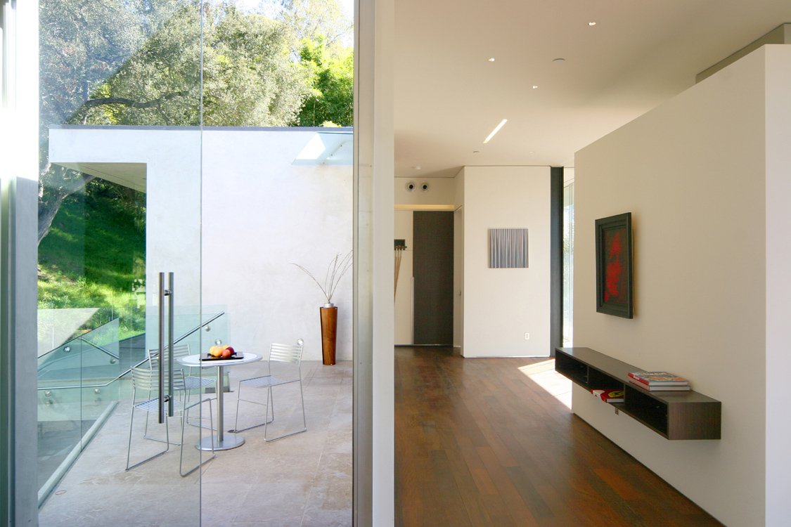 Architecture and design of residence designed to protect trees and to maximize views and breezes in Benedict Canyon. View of hallway and back patio.