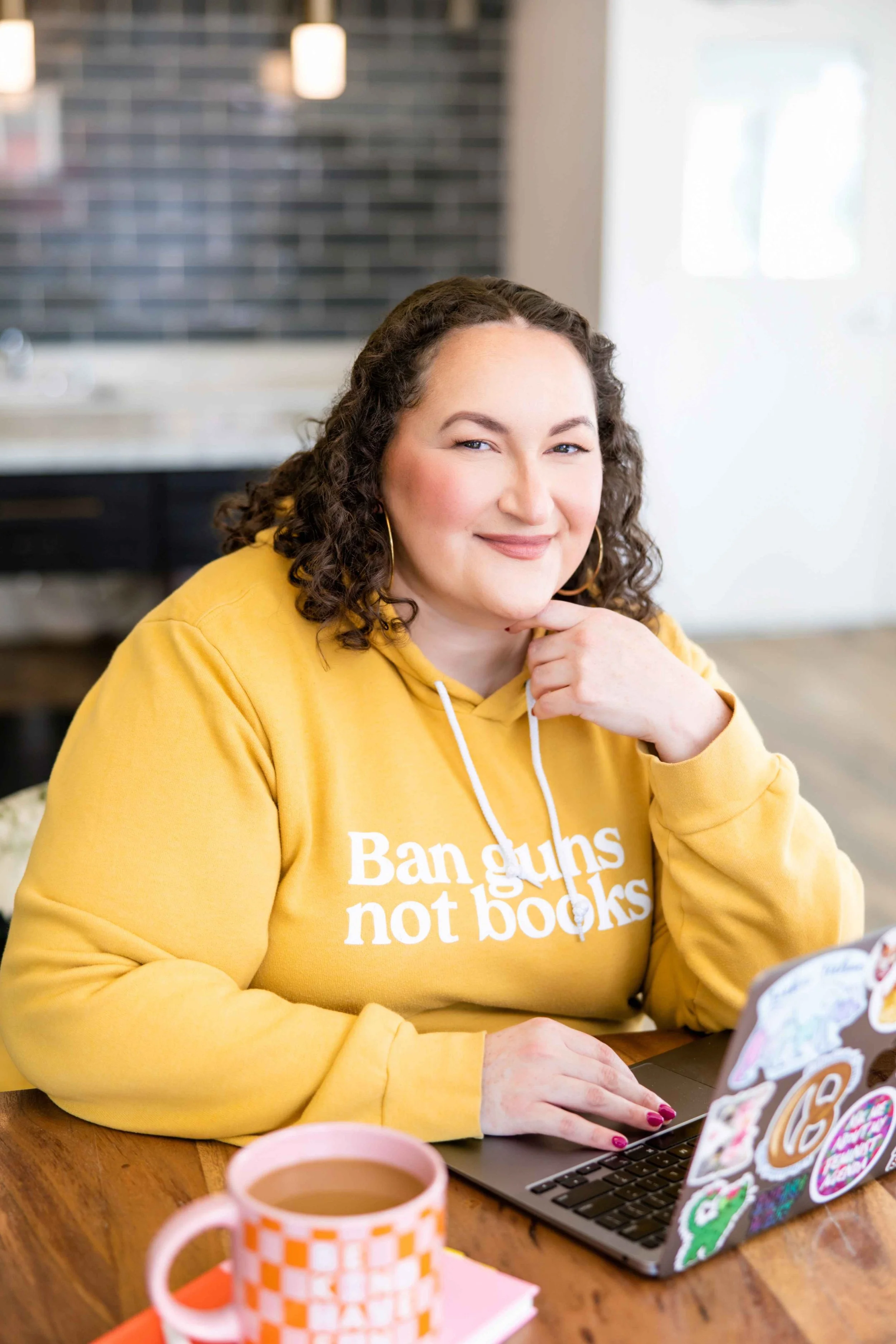 Golden Poppy Digital Owner Tori sitting at a table, smiling at the camera.