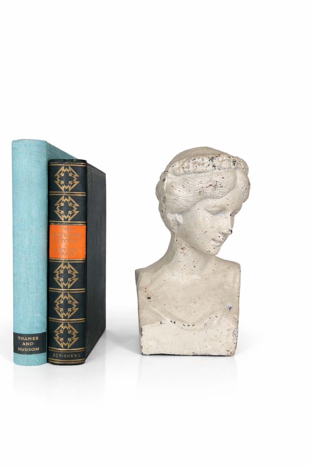 Three books standing upright next to a classical-style bust sculpture of a woman with her head bowed.