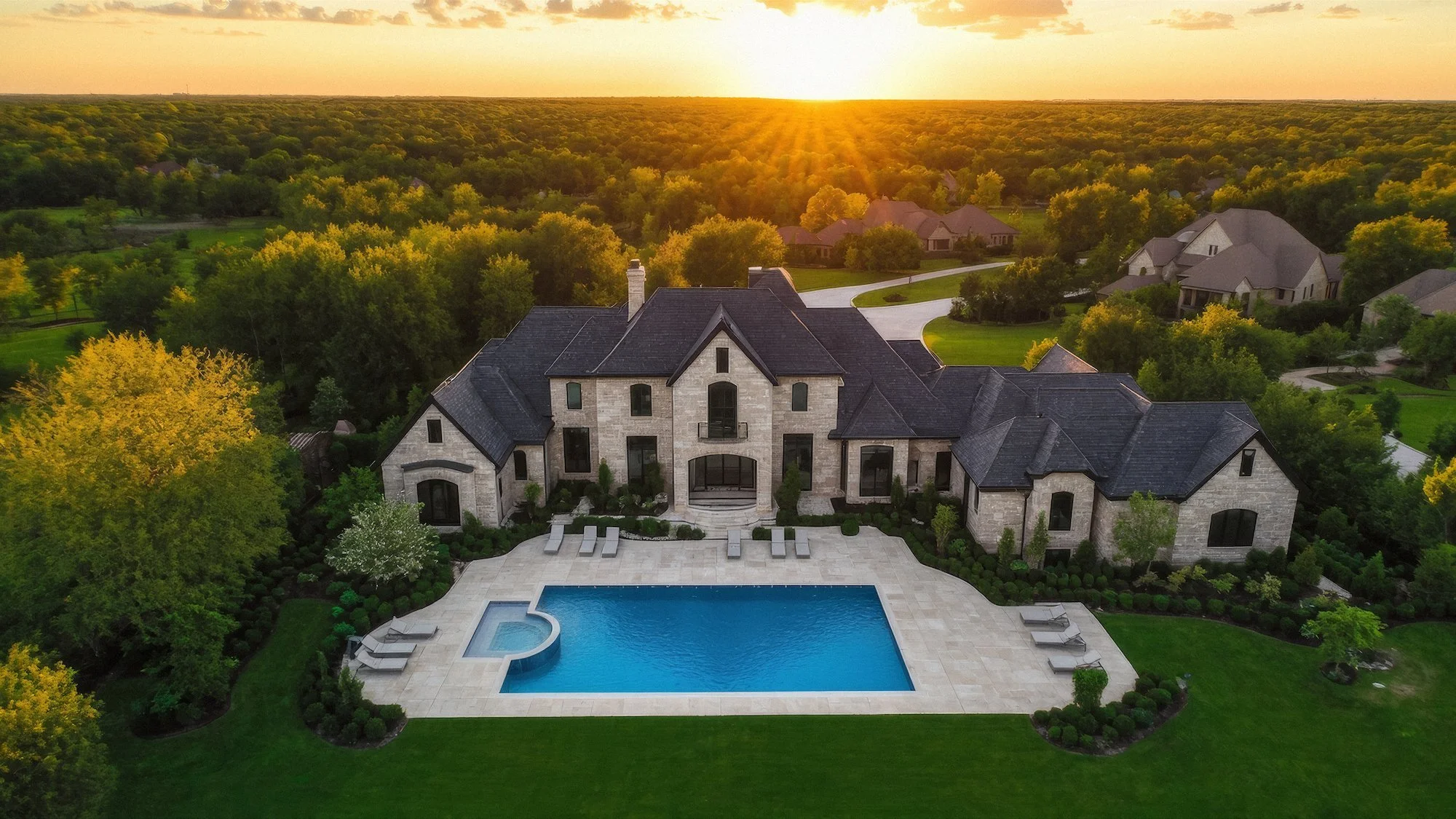 A large luxury house with a swimming pool in the backyard at sunset, surrounded by lush green trees and manicured lawn.