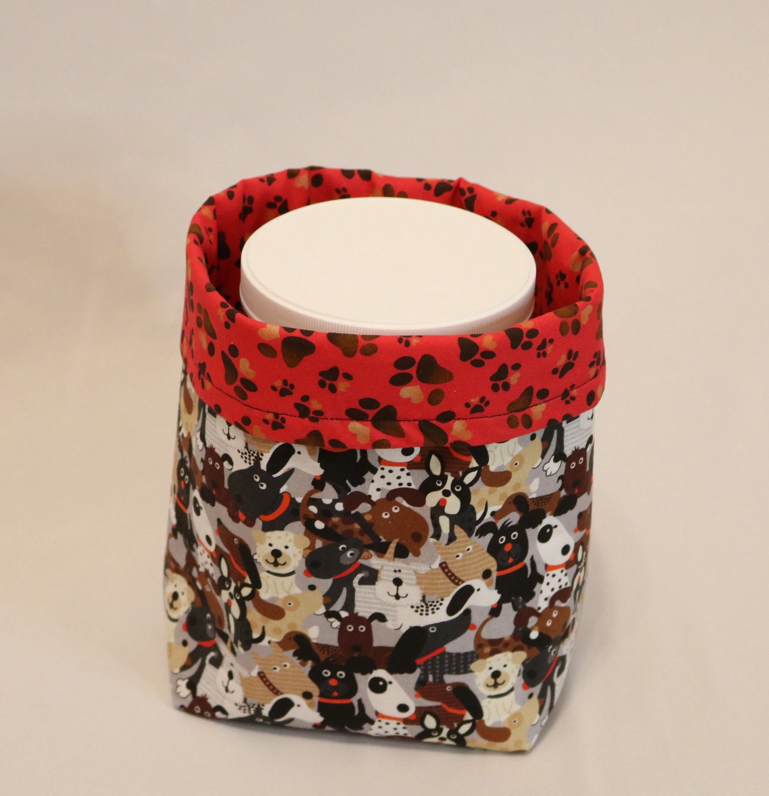 Insulated lunch bag with dog patterns on a plain background, containing a white container.