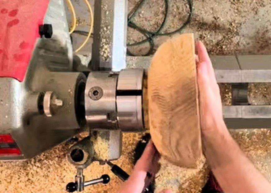 Scroll chuck holding a wood bowl by its tenon.
